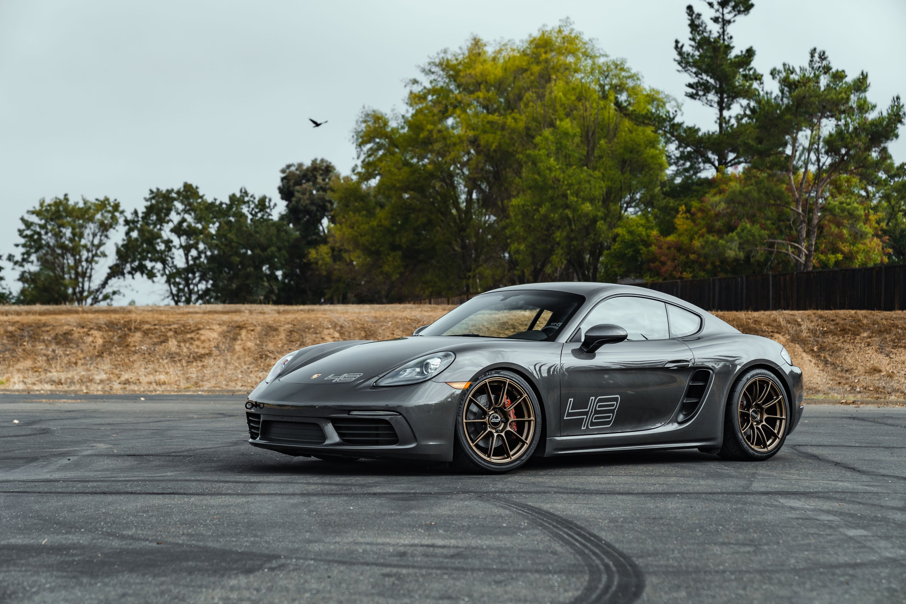 Grey Porsche 718 Cayman S with 19" SM-10RS Apex wheels in Satin Bronze
