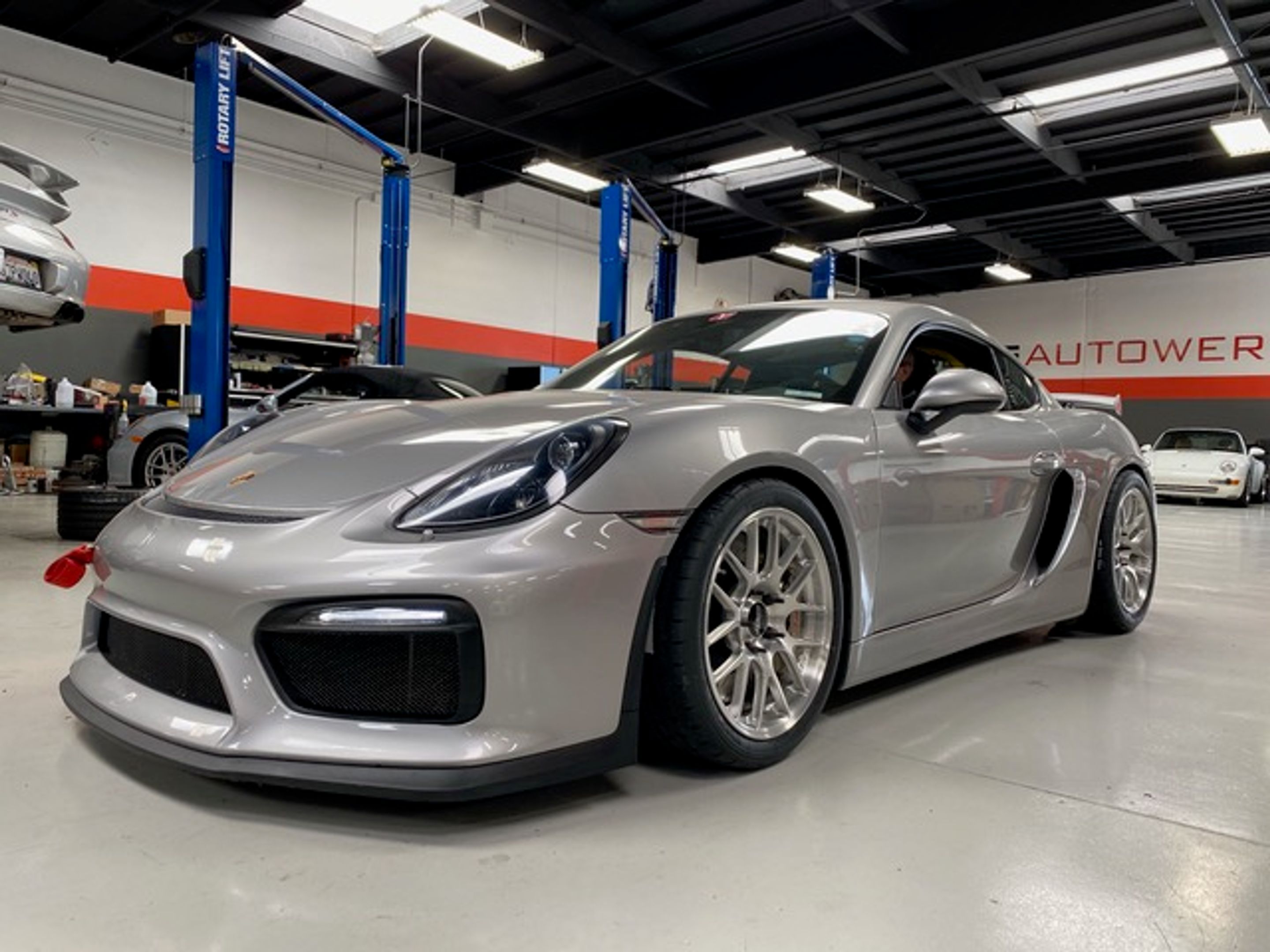 Silver Porsche 981 Cayman GT4 with 18" EC-7R Apex wheels in Brushed Clear
