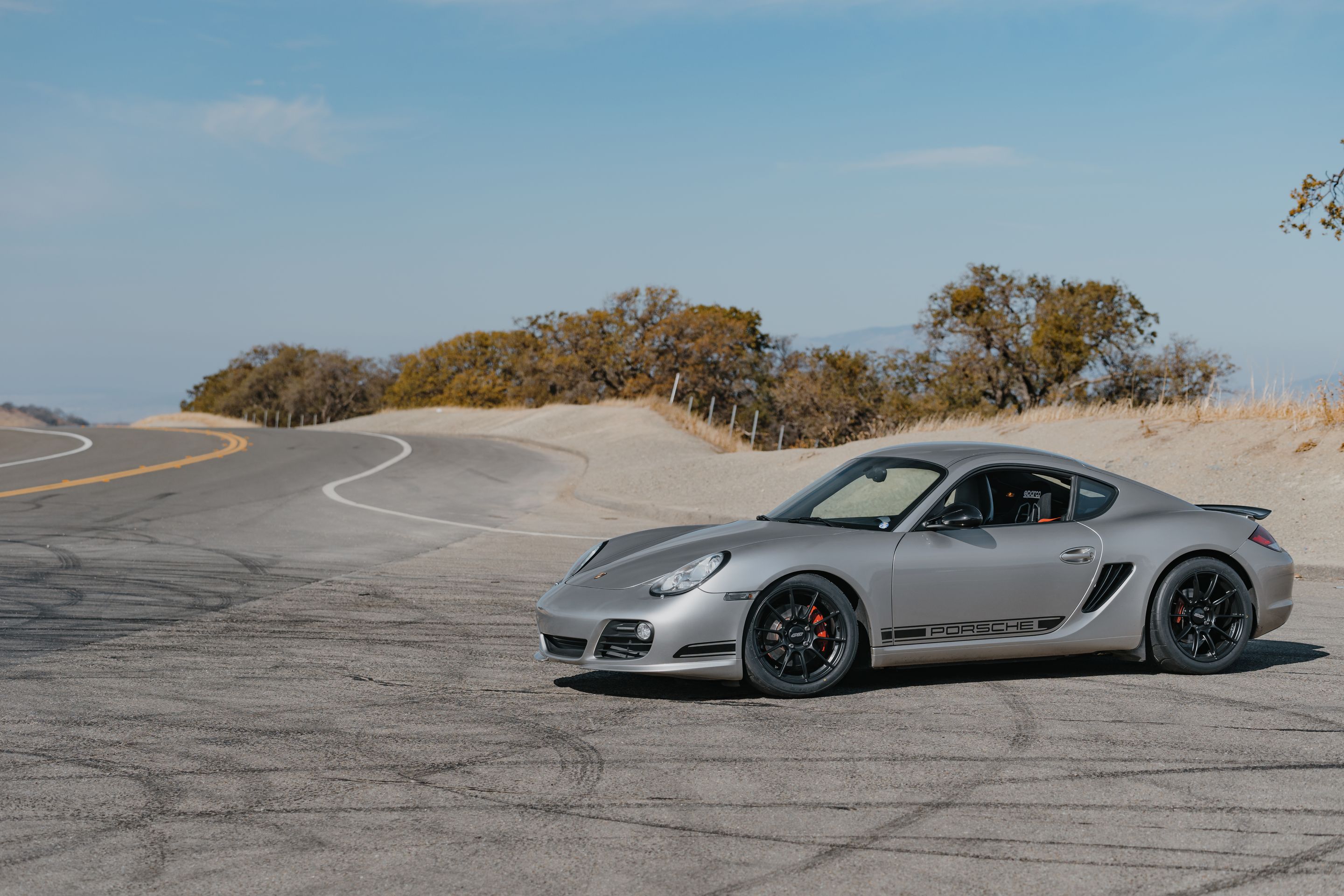 Silver Porsche 987 Cayman R with 18" SM-10RS Apex wheels in Satin Black