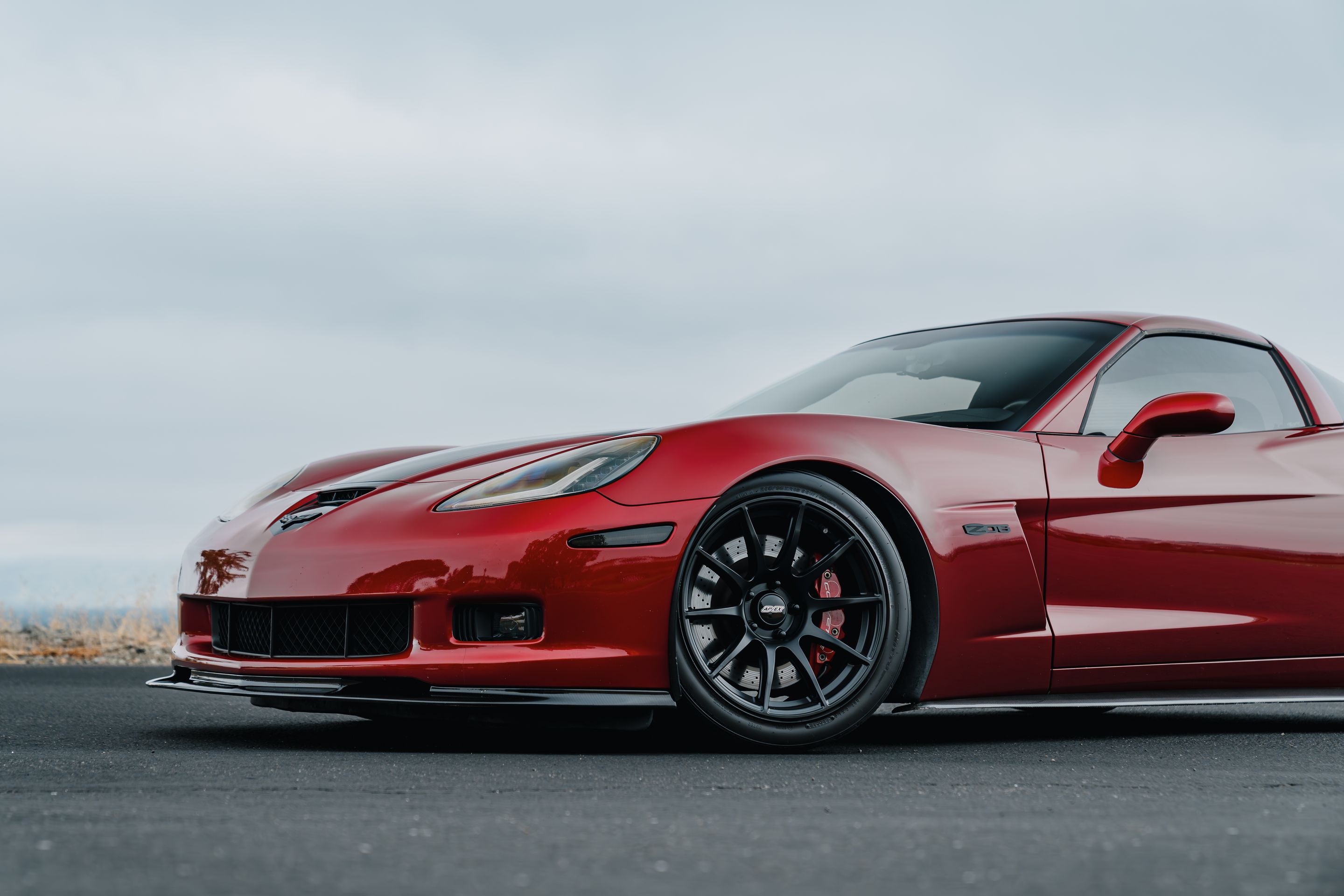 Red Chevrolet C6 Corvette Z06 with 18"/19" SM-10 Apex wheels in Satin Black