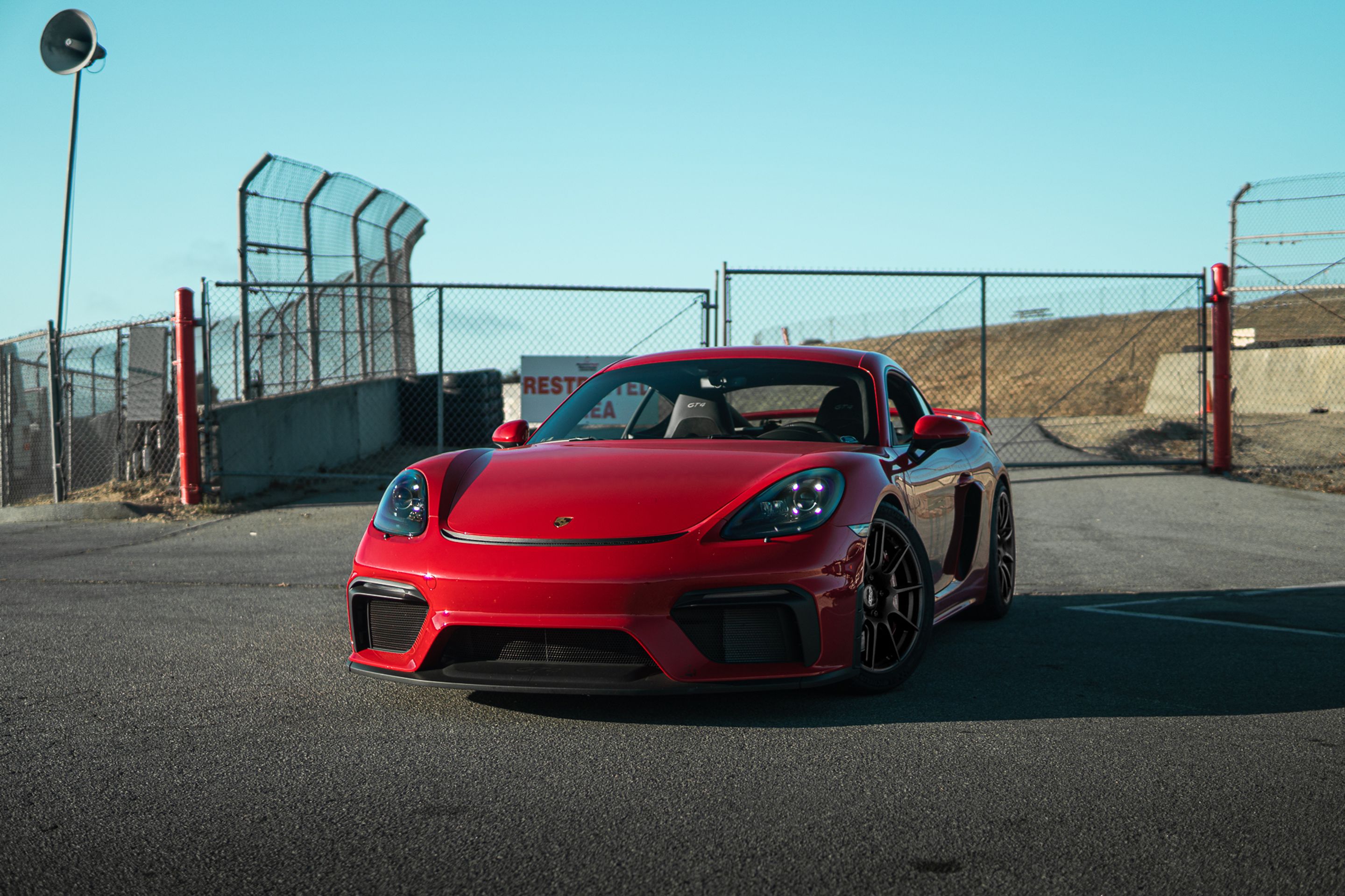 Red Porsche 718 Cayman GT4 with 19" SM-10 Apex wheels in Satin Black