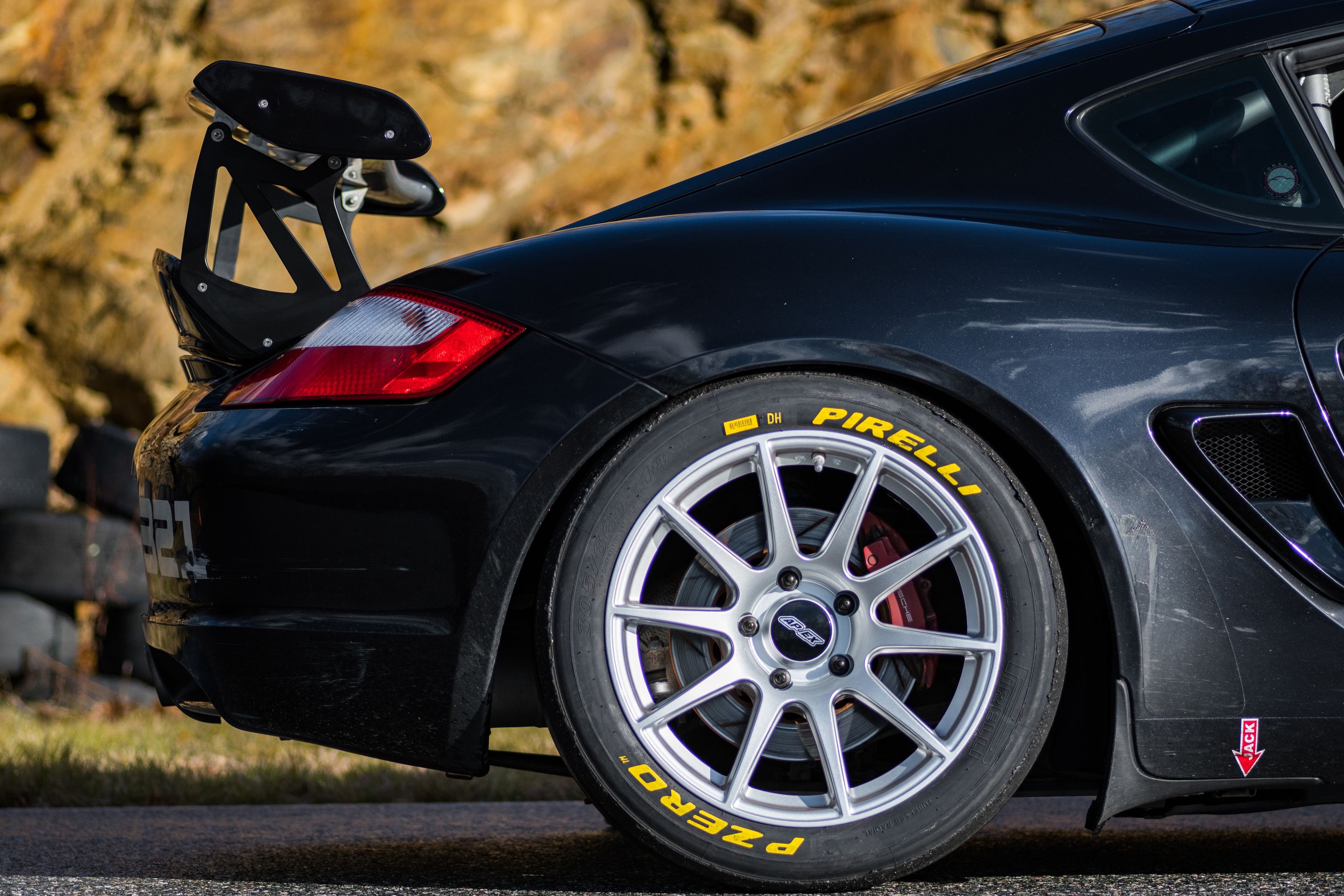 Black Porsche 987 Cayman S with 18" SM-10 Apex wheels in Race Silver
