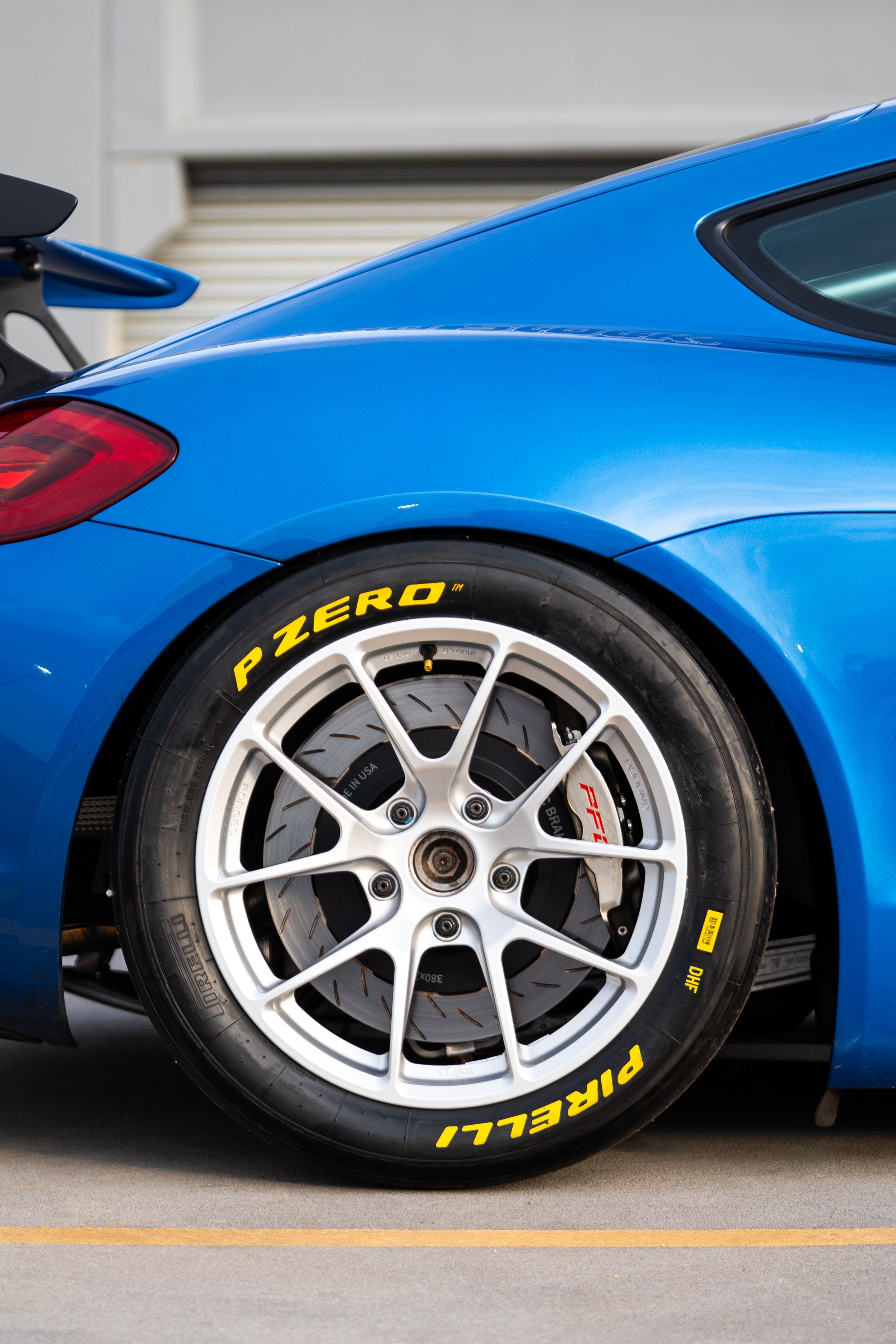 Blue Porsche 981 Cayman GT4 with 18" VS-5RE Apex wheels in Race Silver