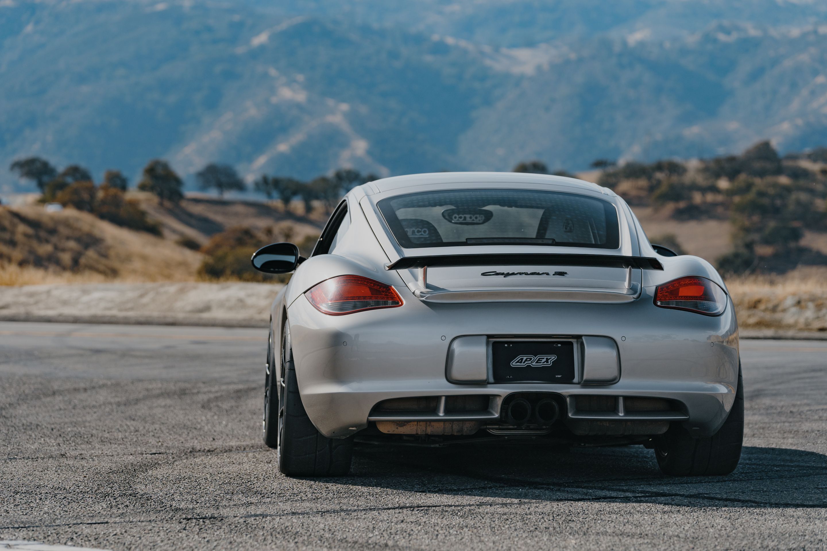 Silver Porsche 987 Cayman R with 18" SM-10RS Apex wheels in Satin Black