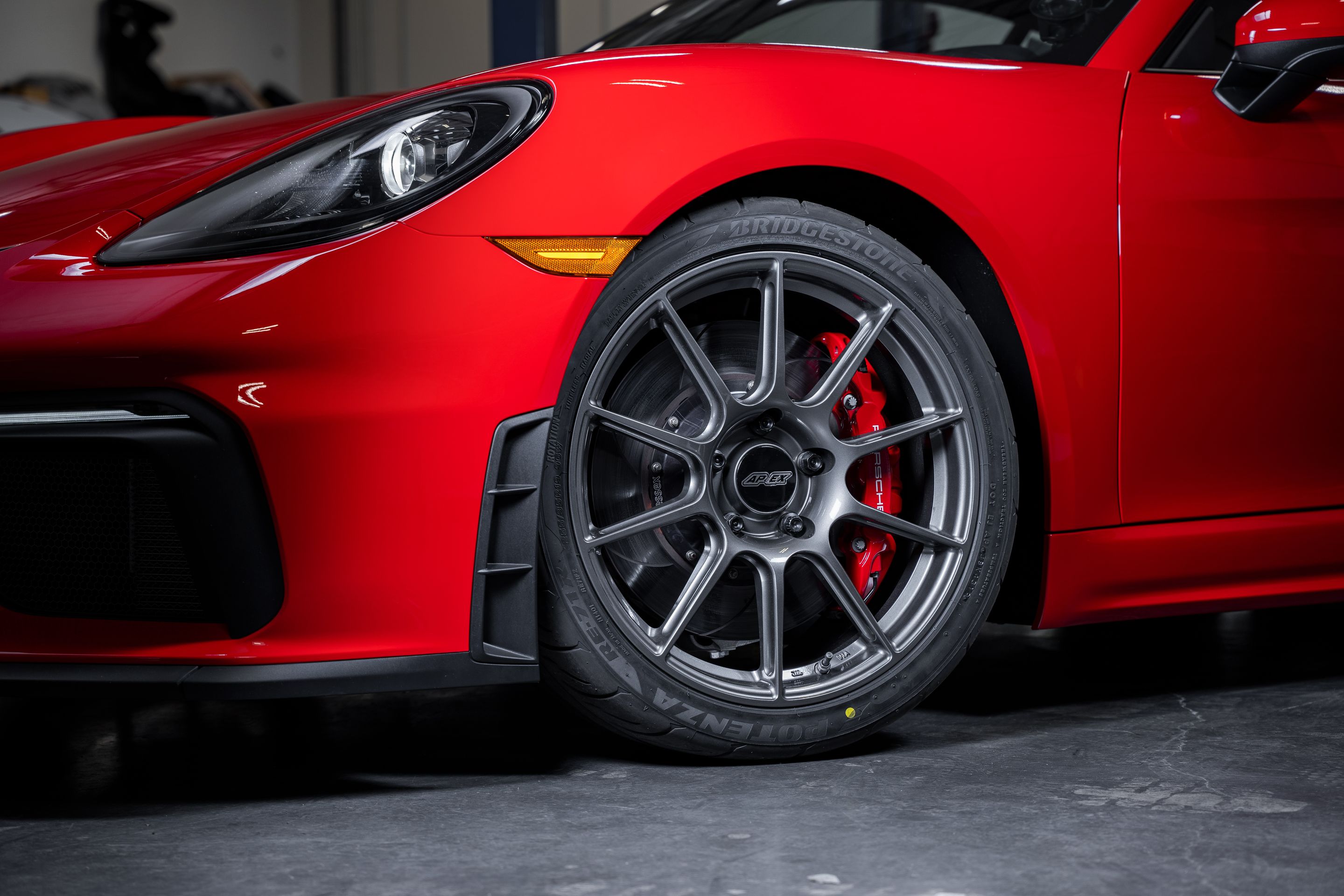 Red Porsche 718 Cayman GT4 with 19" SM-10 Apex wheels in Anthracite