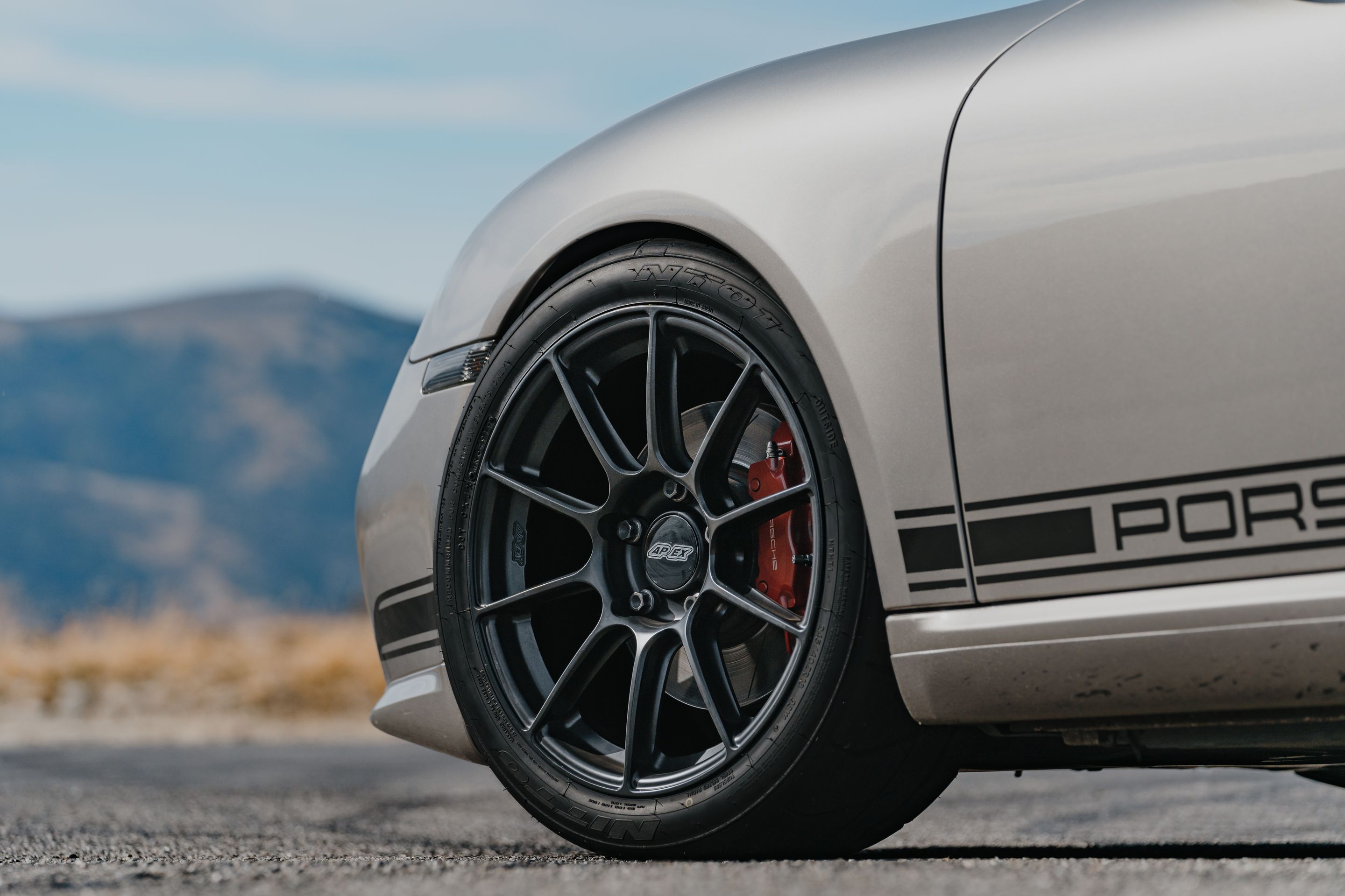 Silver Porsche 987 Cayman R with 18" SM-10RS Apex wheels in Satin Black