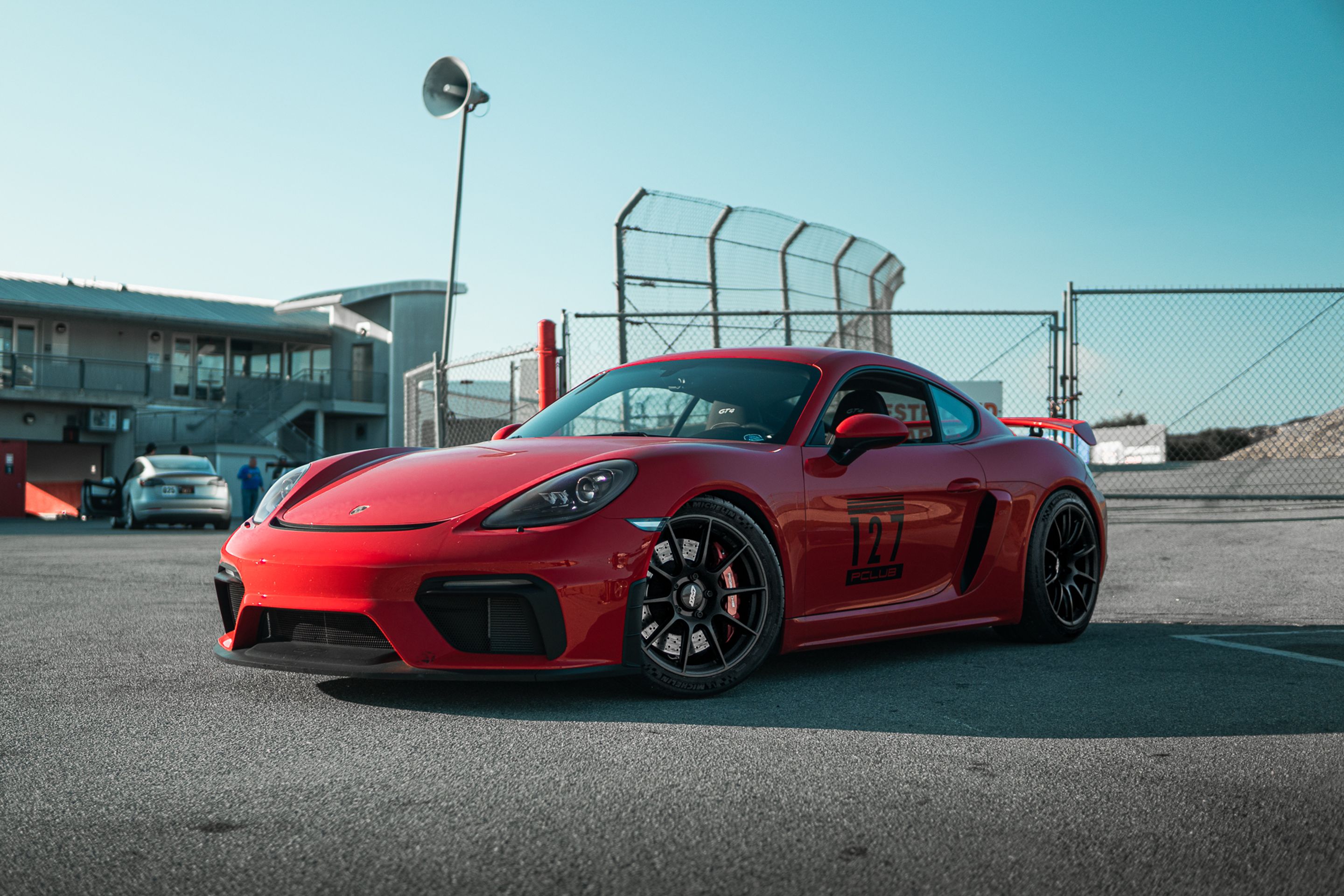 Red Porsche 718 Cayman GT4 with 19" SM-10 Apex wheels in Satin Black