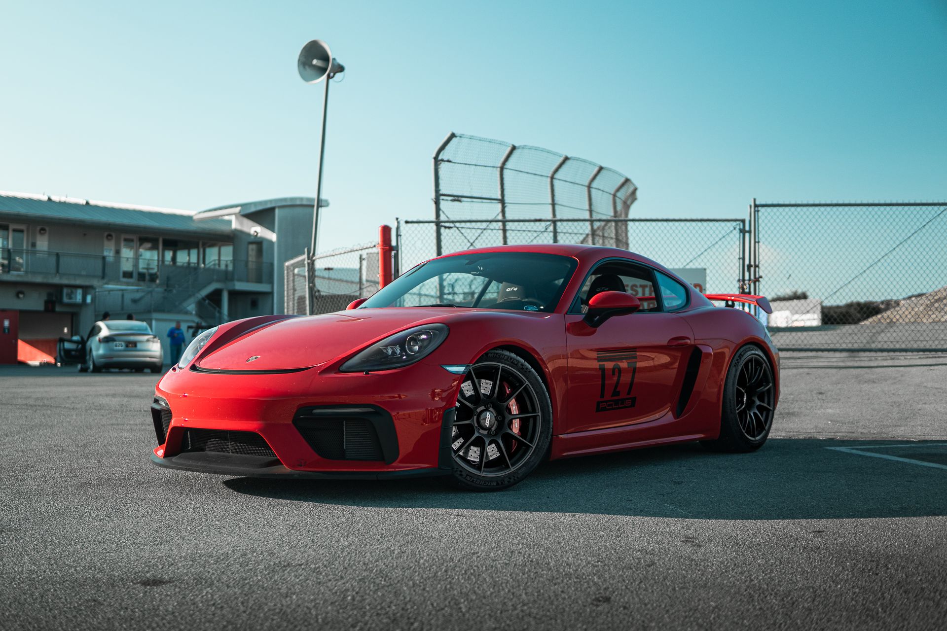 Red Porsche 718 Cayman GT4 with 19" SM-10 Apex wheels in Satin Black