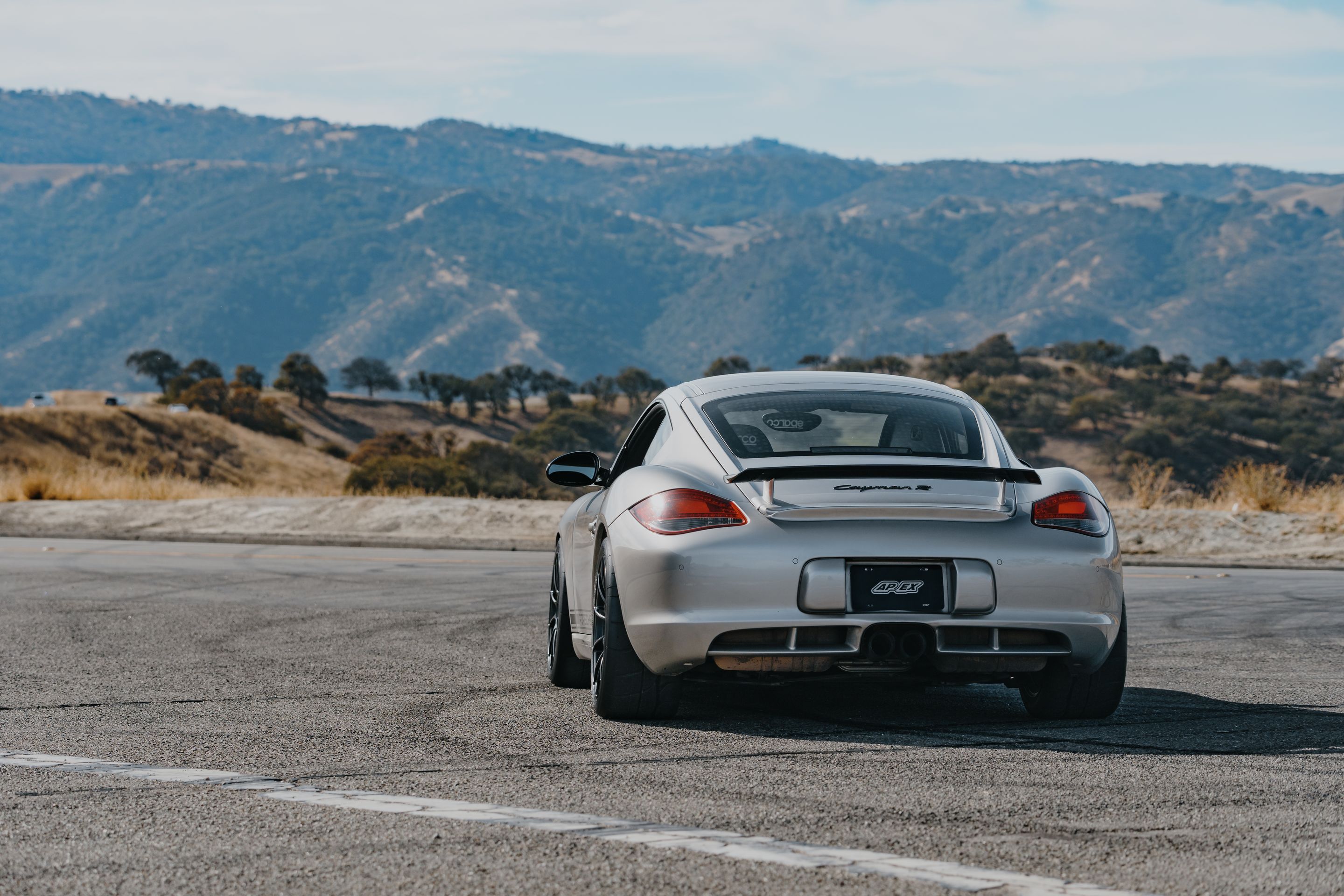 Silver Porsche 987 Cayman R with 18" SM-10RS Apex wheels in Satin Black