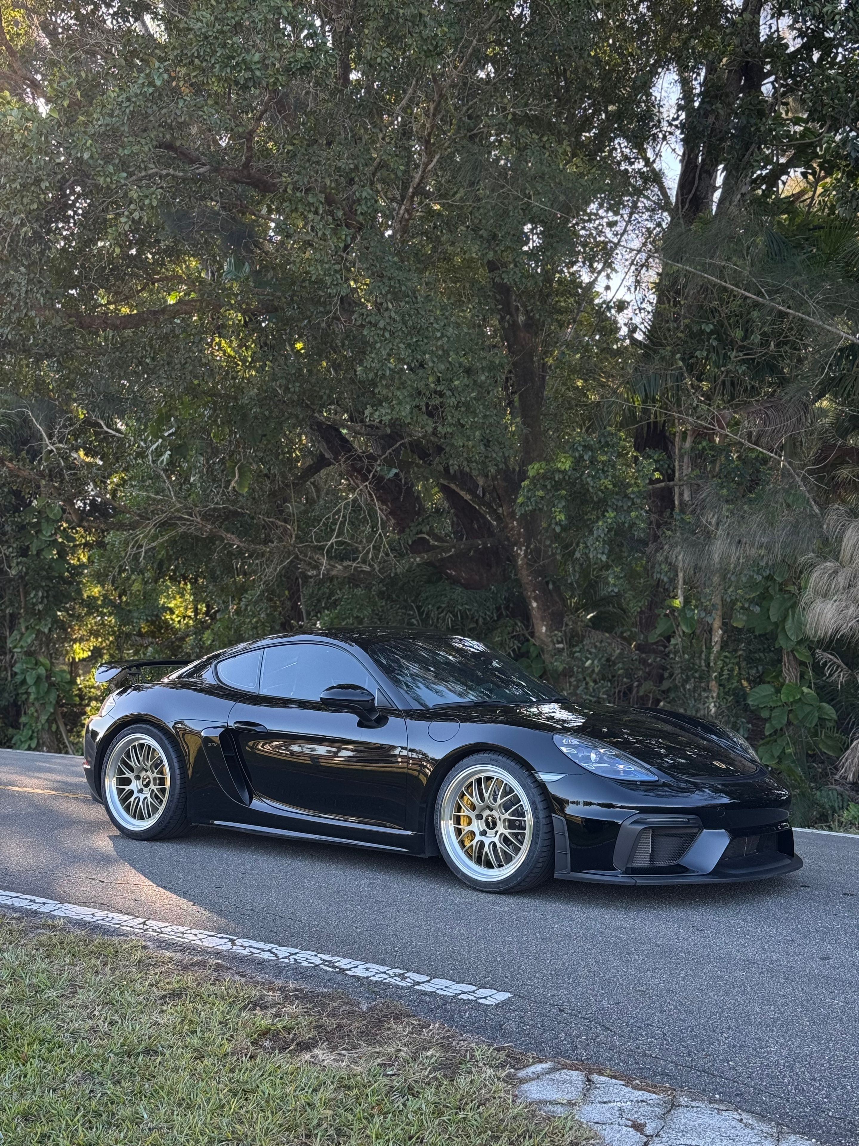 Black Porsche 718 Cayman GT4 with 20" ML-10RT Apex wheels in Machined Lip Gloss Motorsport Gold