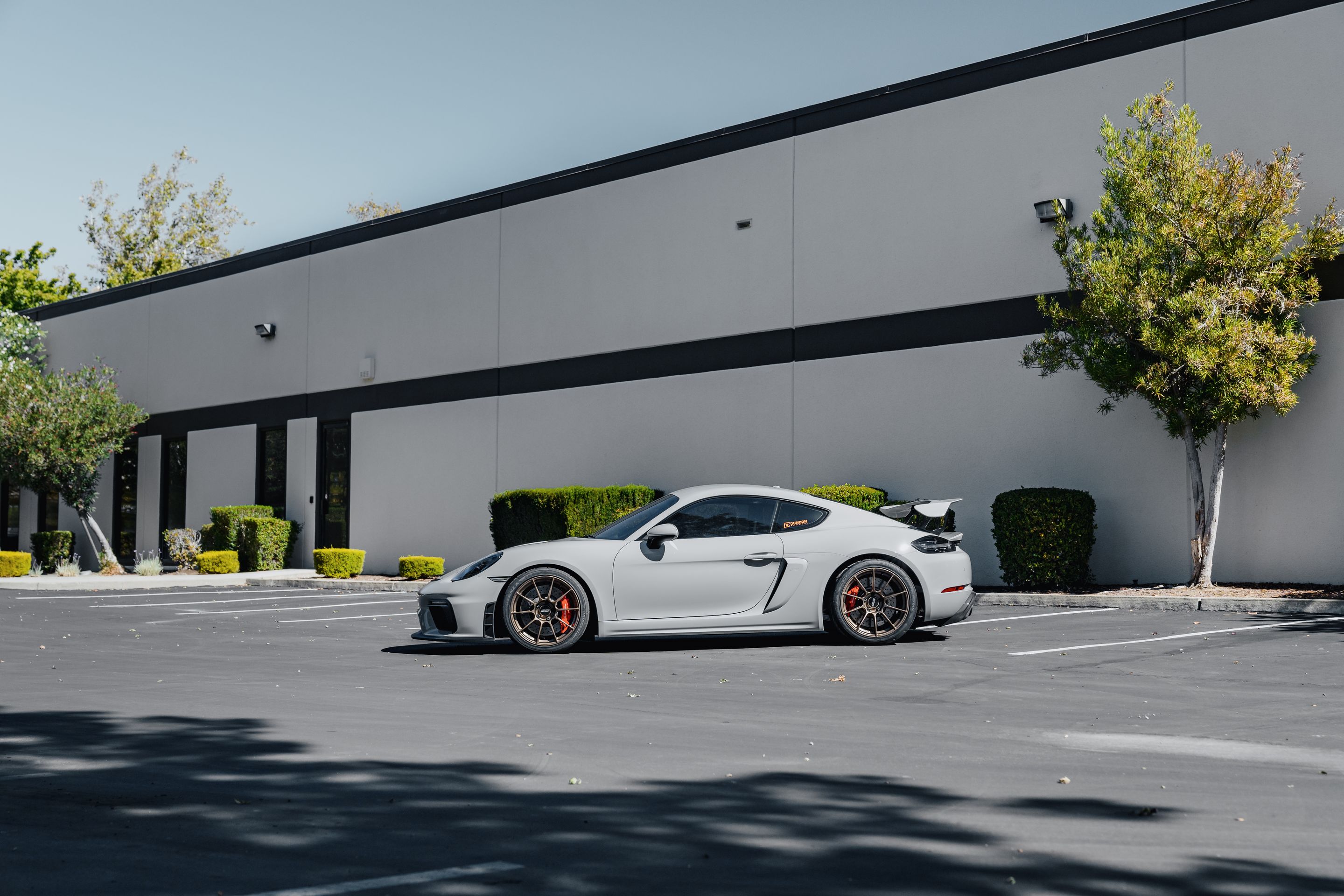 Grey Porsche 718 Cayman GT4 with 19" SM-10RS Apex wheels in Satin Bronze