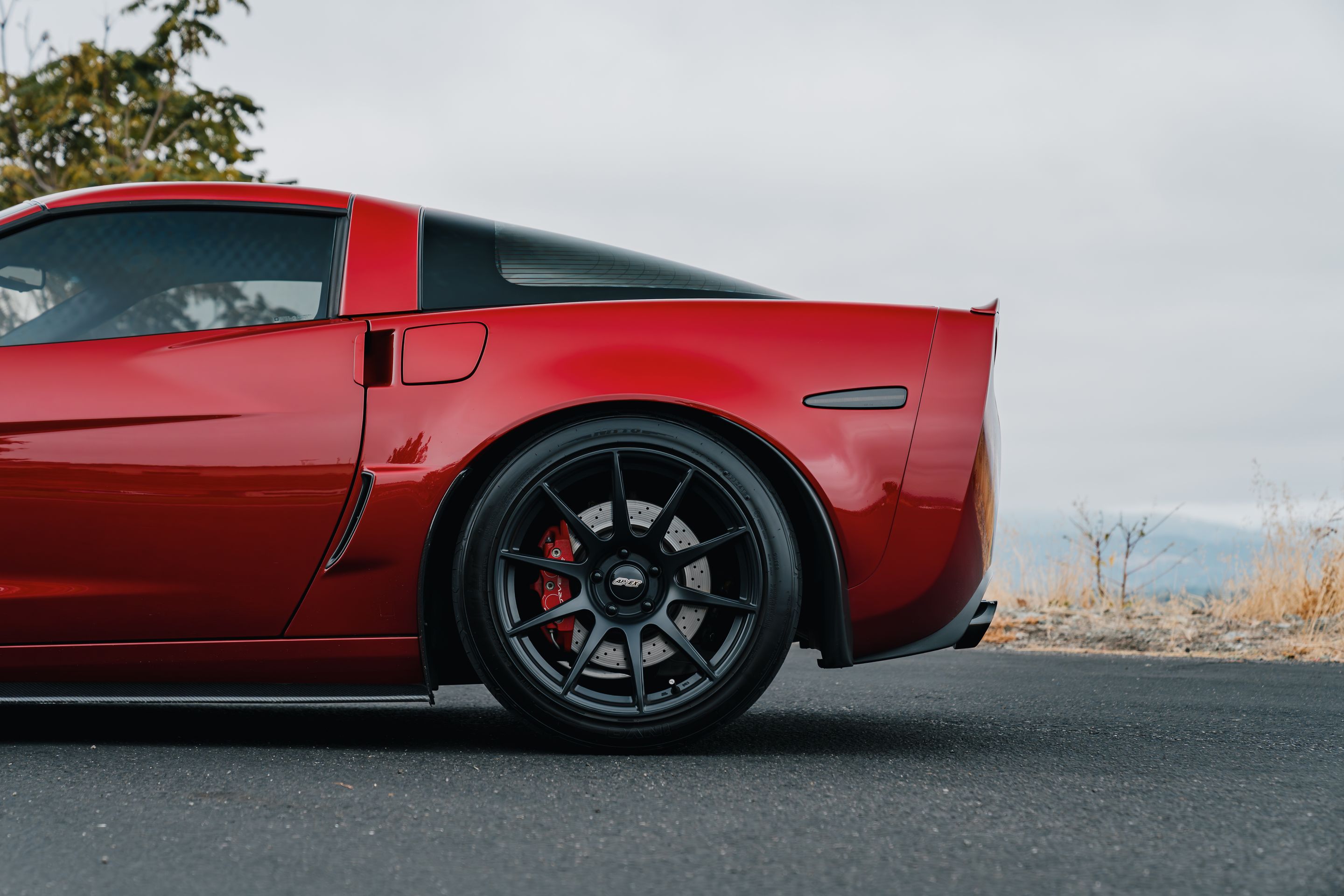 Red Chevrolet C6 Corvette Z06 with 18"/19" SM-10 Apex wheels in Satin Black