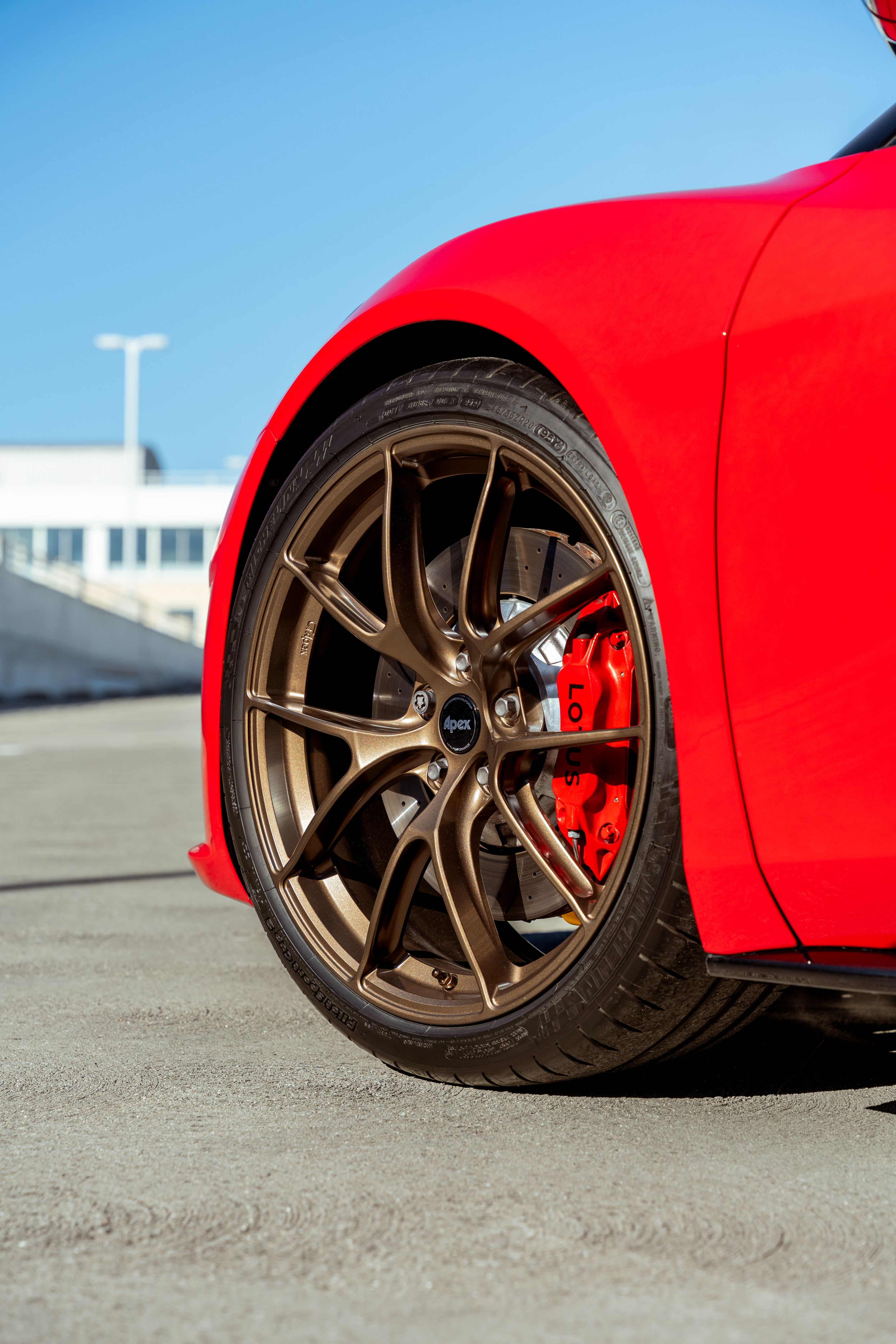 Red Lotus Emira with 20" VS-5RS Apex wheels in Anthracite