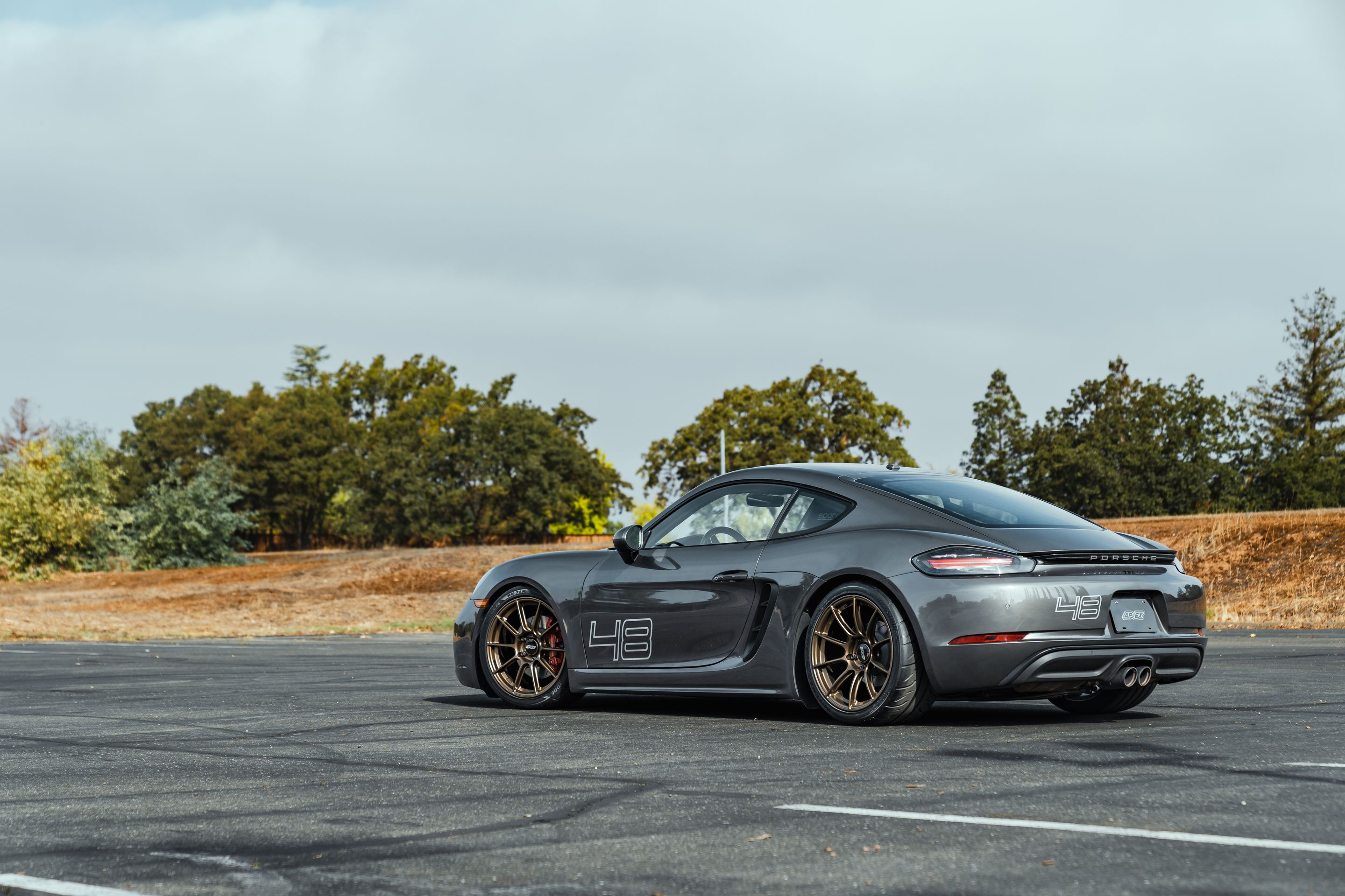 Grey Porsche 718 Cayman S with 19" SM-10RS Apex wheels in Satin Bronze
