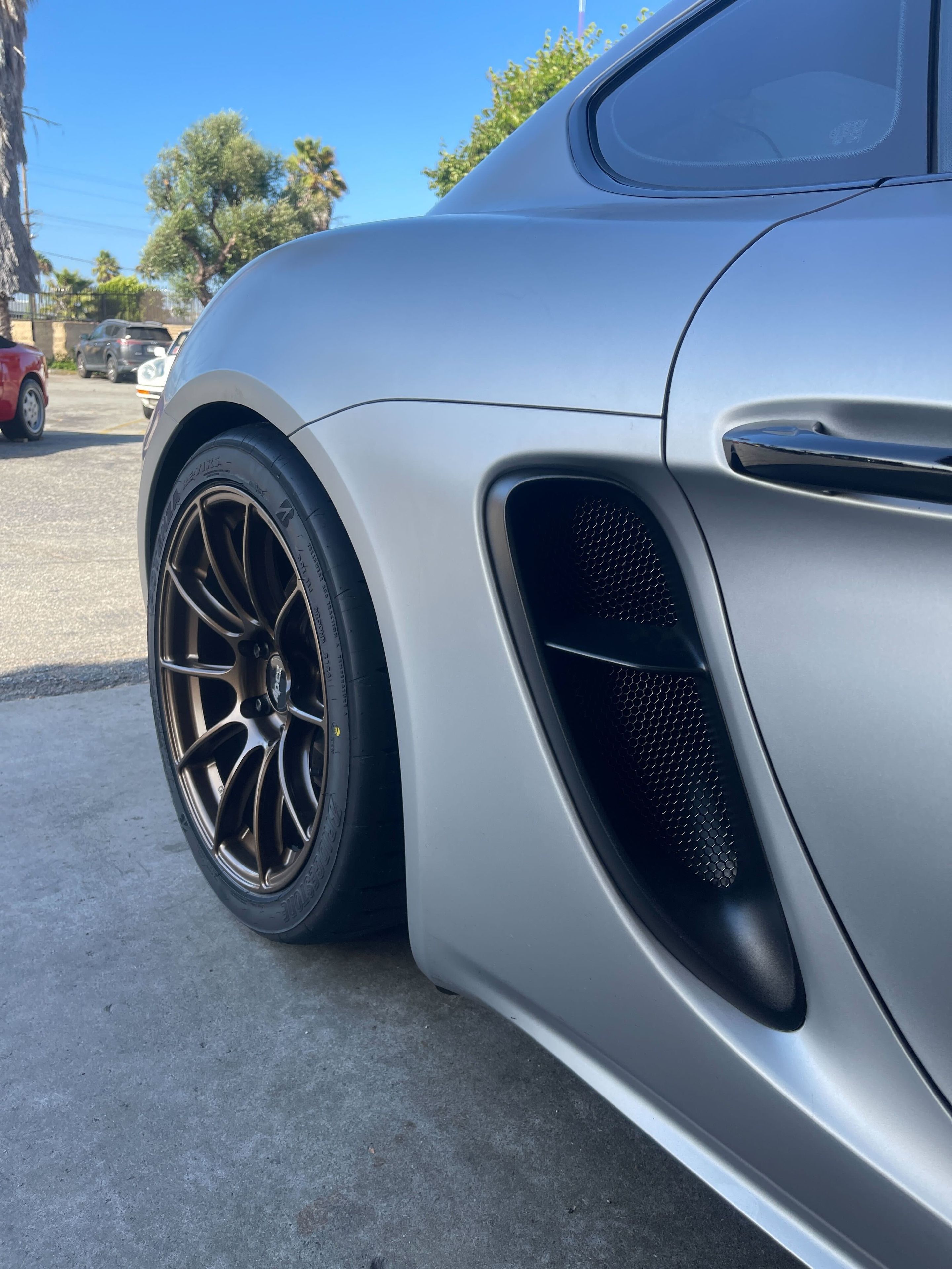 Silver Porsche 718 Cayman GTS 4.0L with 19" SM-10RS Apex wheels in Satin Bronze