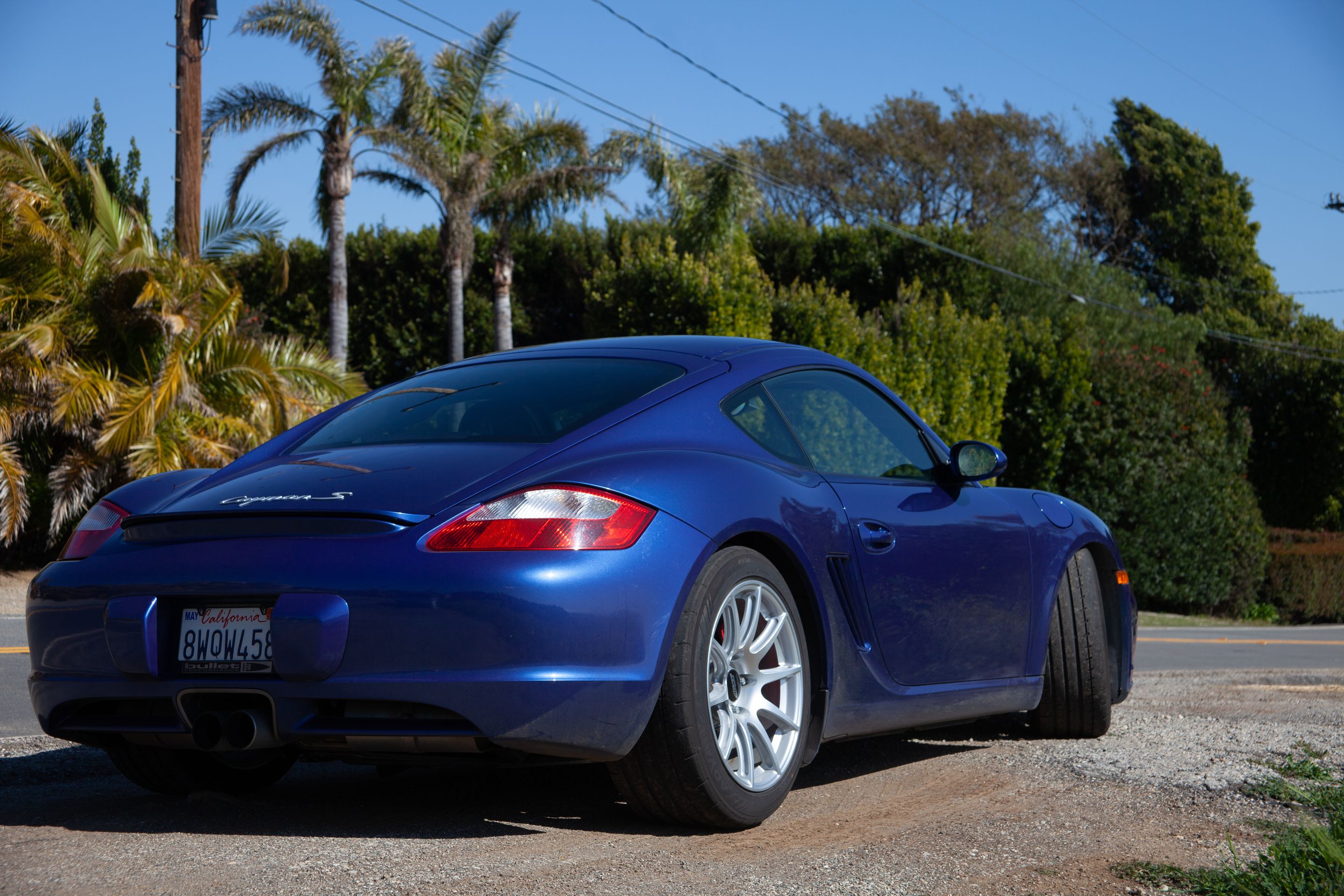 Blue Porsche 987 Cayman S with 18" SM-10 Apex wheels in Race Silver