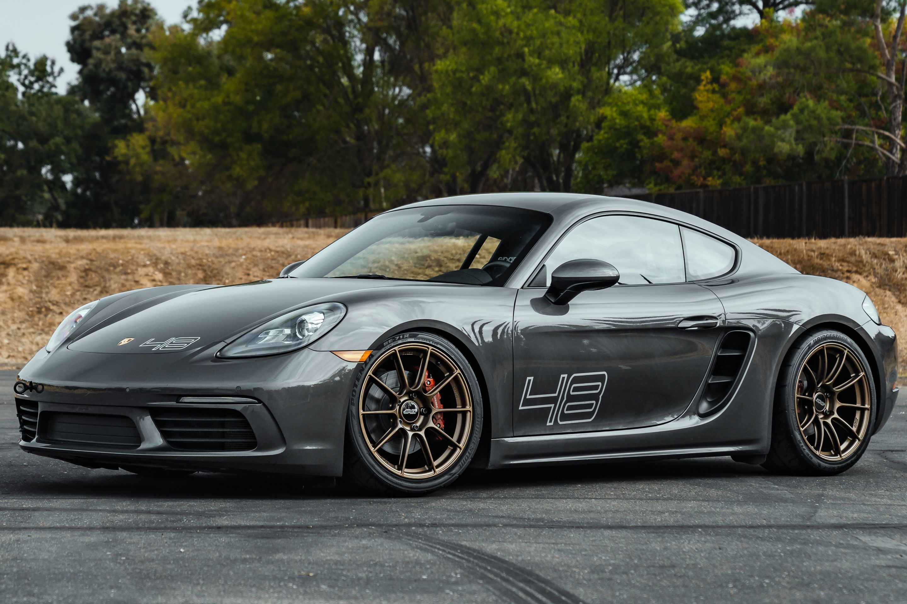 Grey Porsche 718 Cayman S with 19" SM-10RS Apex wheels in Satin Bronze