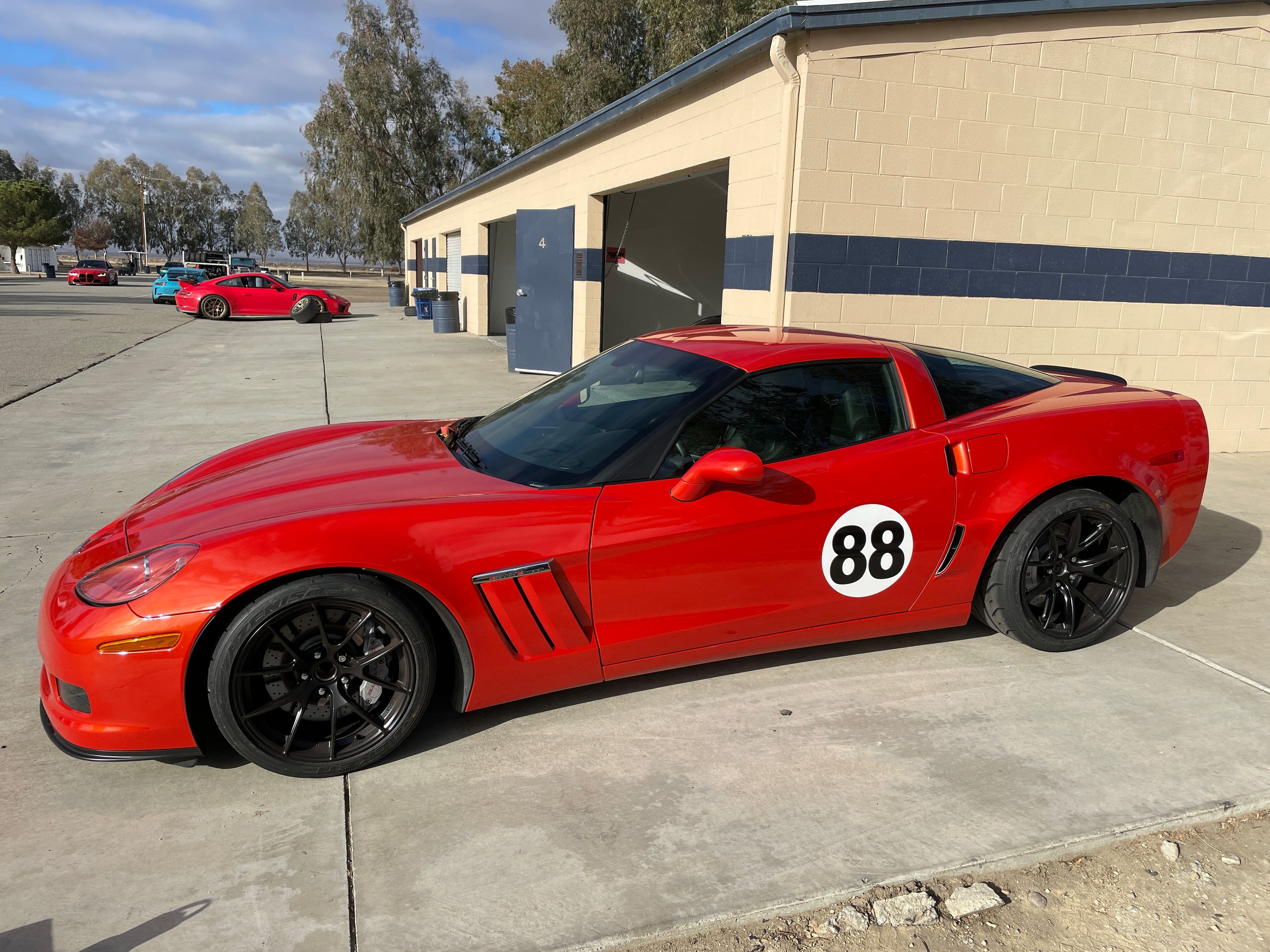 Orange Chevrolet C6 Corvette Grand Sport with 18" VS-5RS Apex wheels in Satin Black
