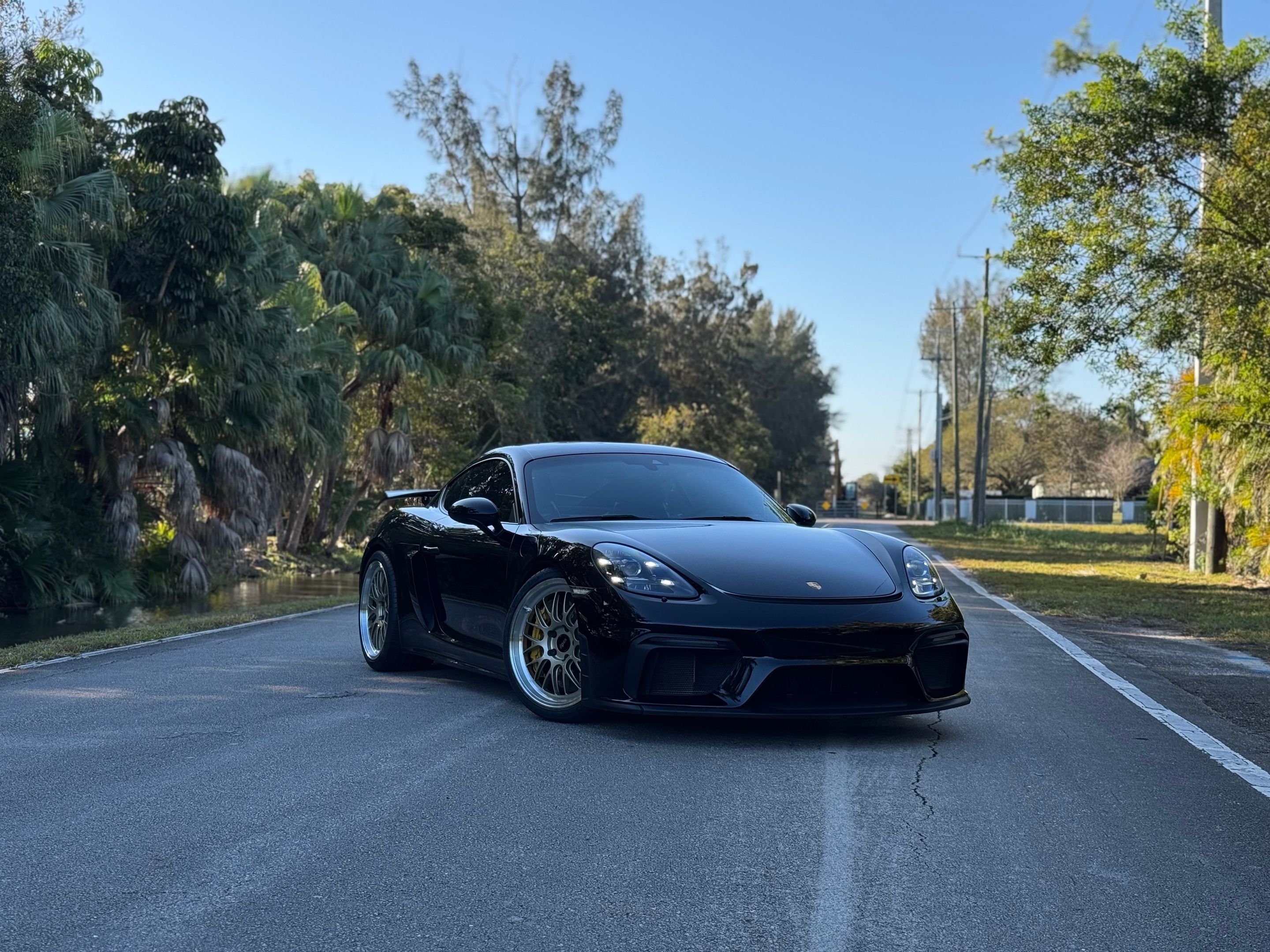 Black Porsche 718 Cayman GT4 with 20" ML-10RT Apex wheels in Machined Lip Gloss Motorsport Gold