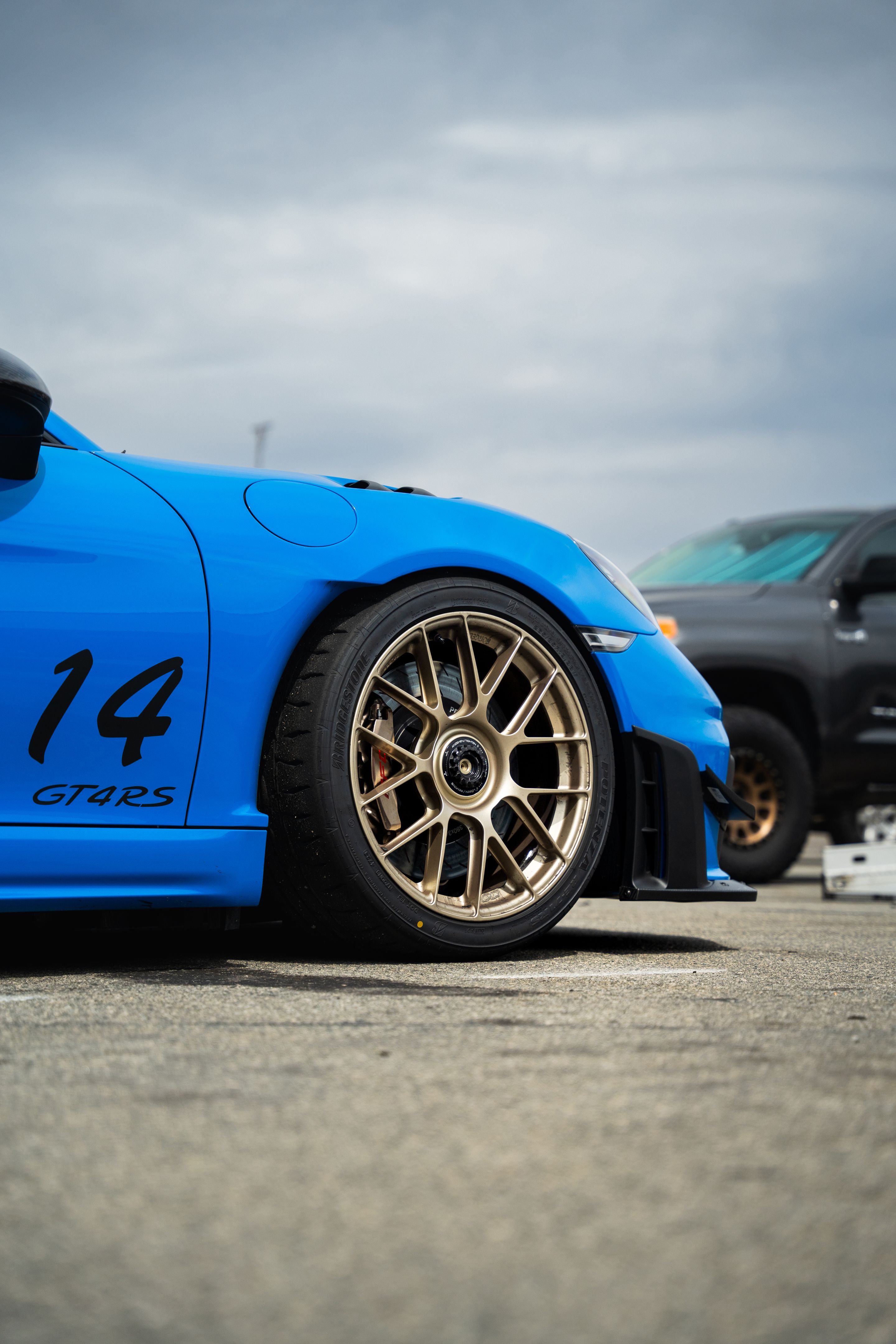 Blue Porsche 718 Cayman GT4 RS with 19" EC-7RS Apex wheels in Motorsport Gold