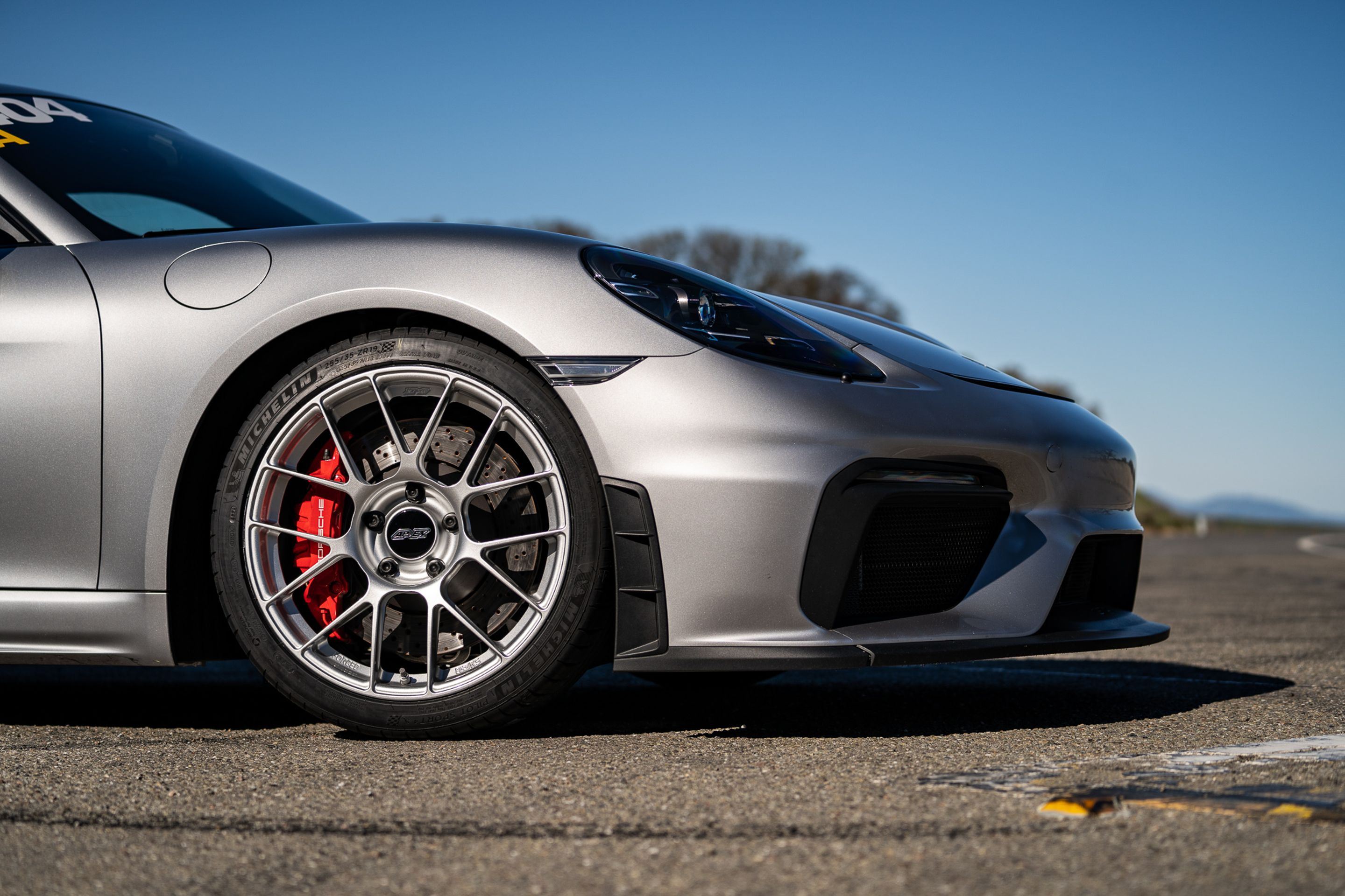 Grey Porsche 718 Cayman GT4 with 19" EC-7RS Apex wheels in Race Silver