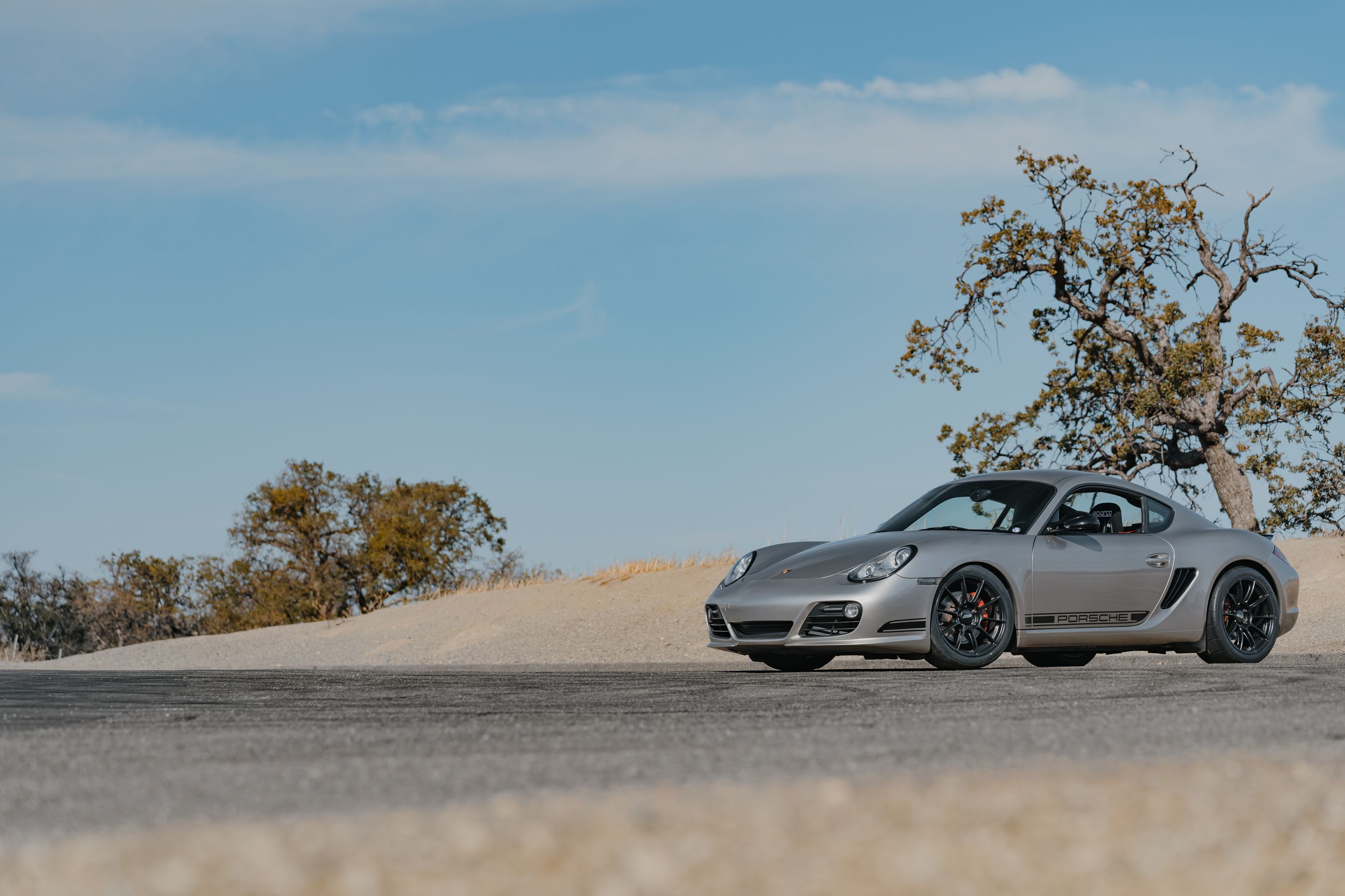 Silver Porsche 987 Cayman R with 18" SM-10RS Apex wheels in Satin Black