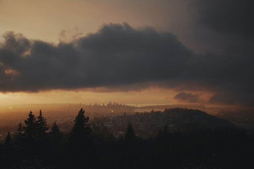 a view of a city from a hill at sunset
