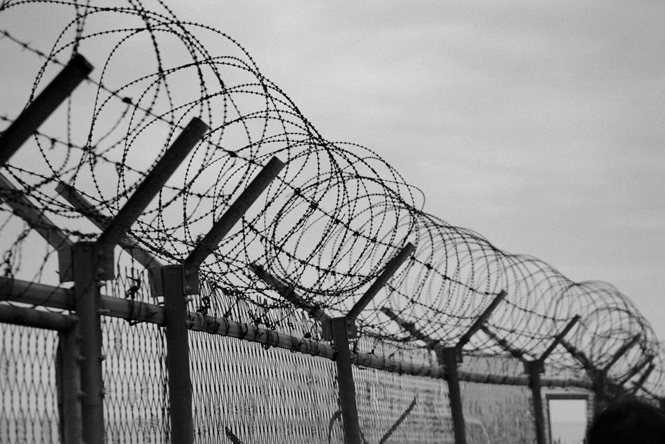 grayscale photo of metal fence