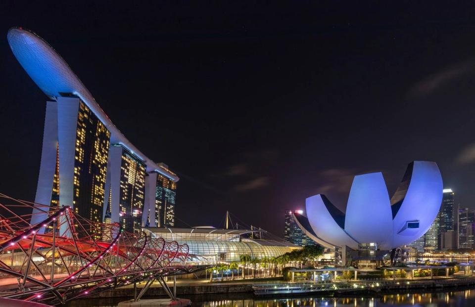 Night view of the illuminated Marina Bay Sands towers, the Helix Bridge and the lotus-shaped ArtScience Museum in Singapore.