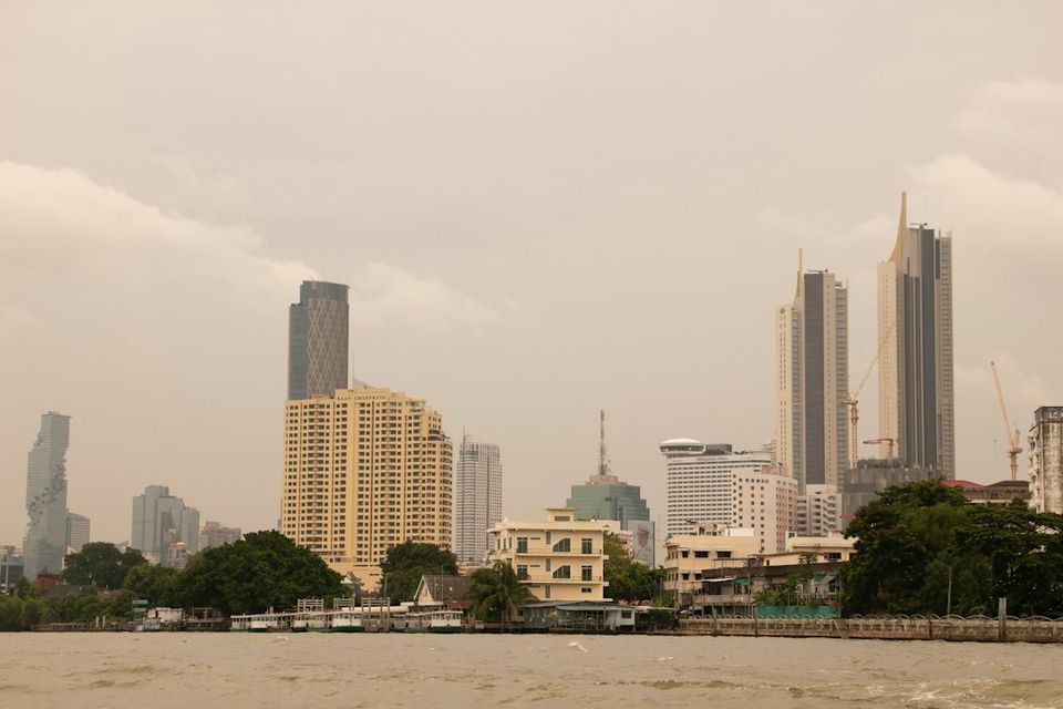 City skyline and river under a hazy, cloudy sky