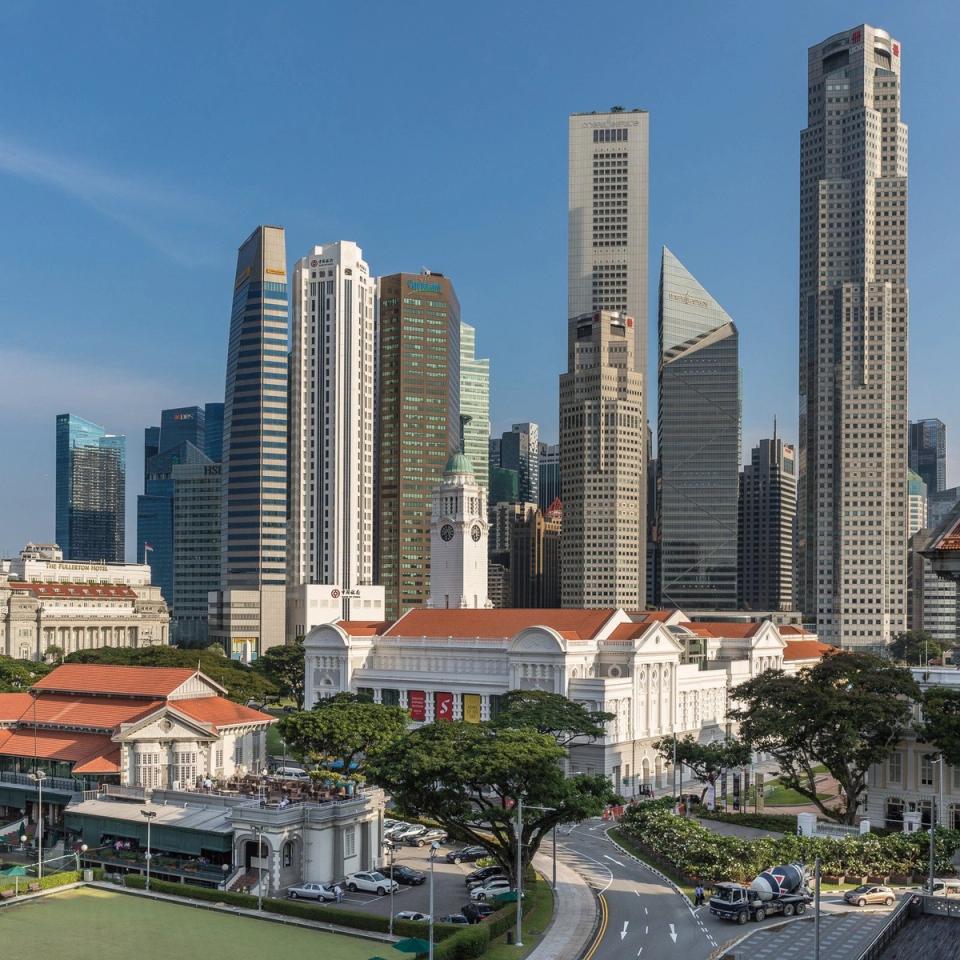 Susur bangunan Pusat Perniagaan Singapura dilihat merentasi air, dengan Old Parliament House di latar depan.