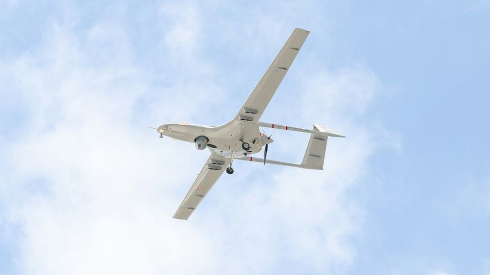 A small airplane flying through a blue sky