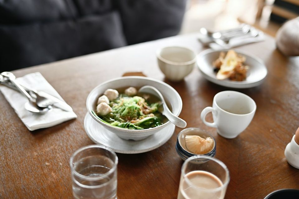 a wooden table topped with a bowl of food