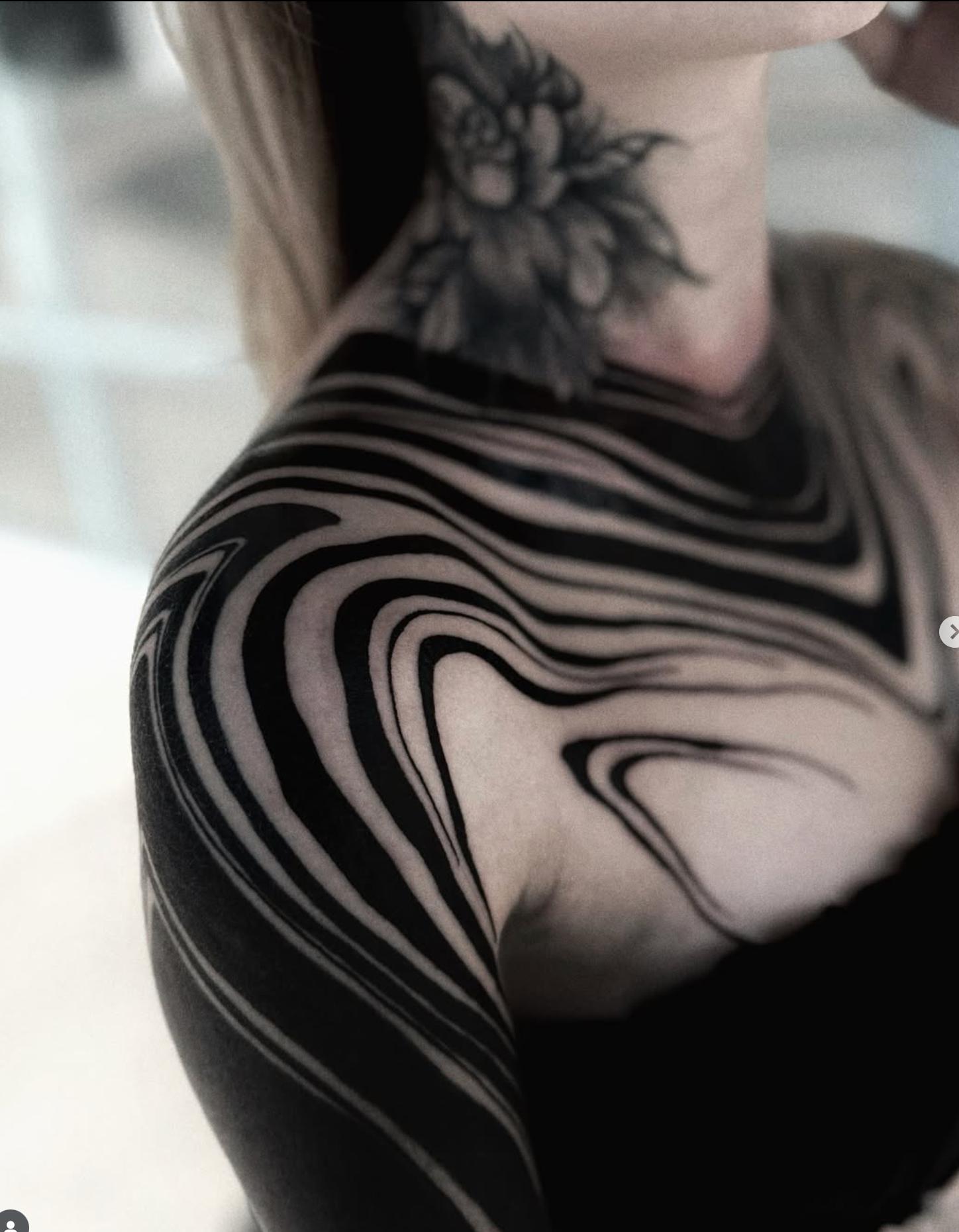 Solid black abstract design covering shoulder and neck