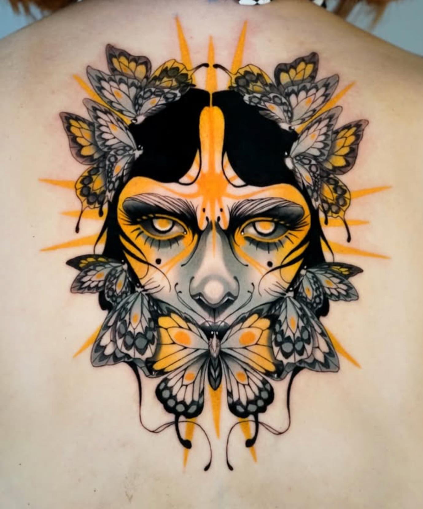 Colorful neotraditional butterfly woman tattoo on upper back