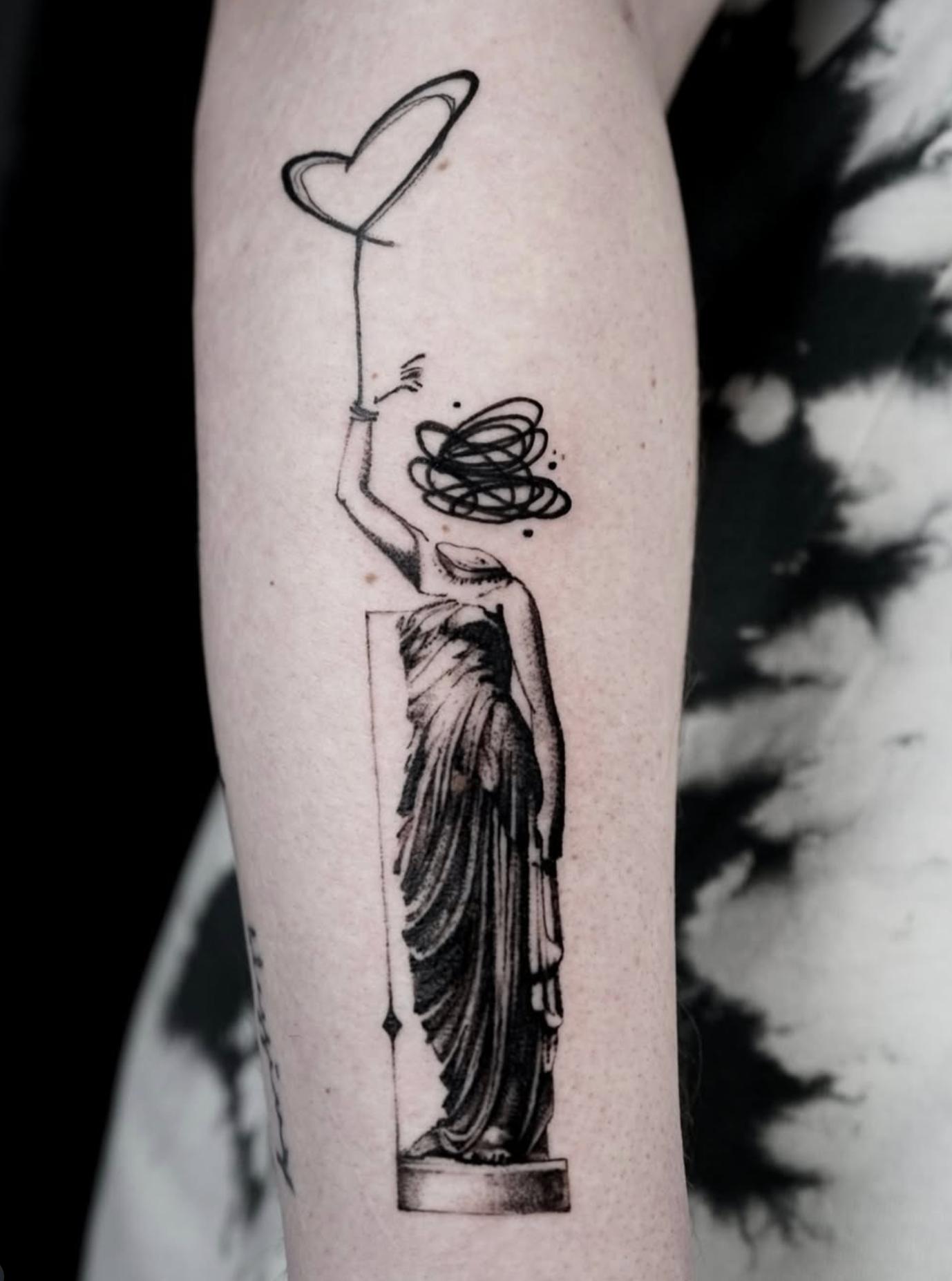 Black and grey abstract statue tattoo on forearm