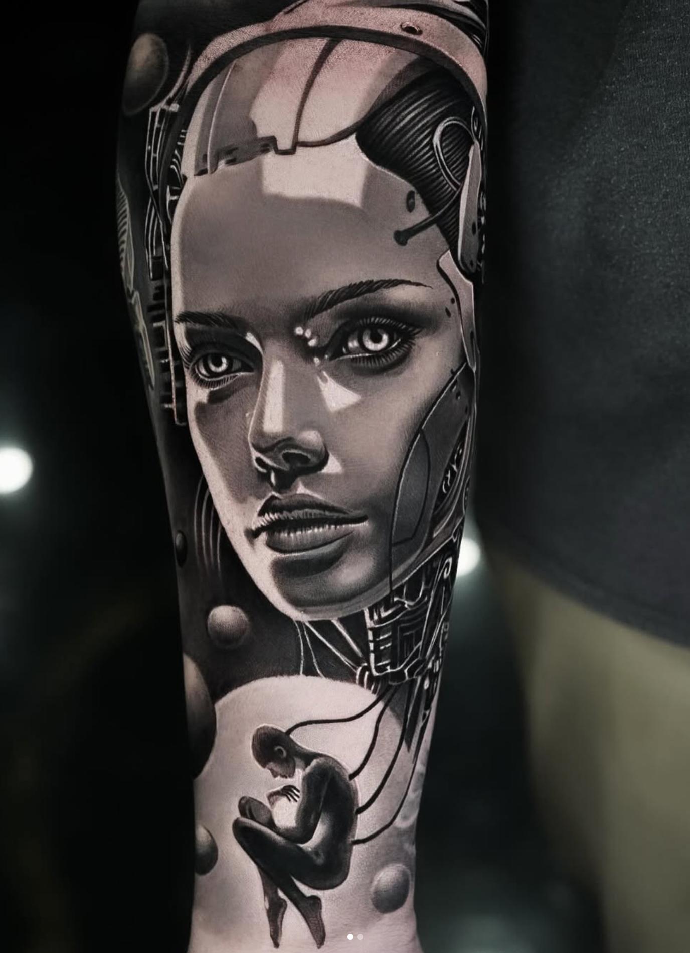Black and grey biomechanical female face on forearm