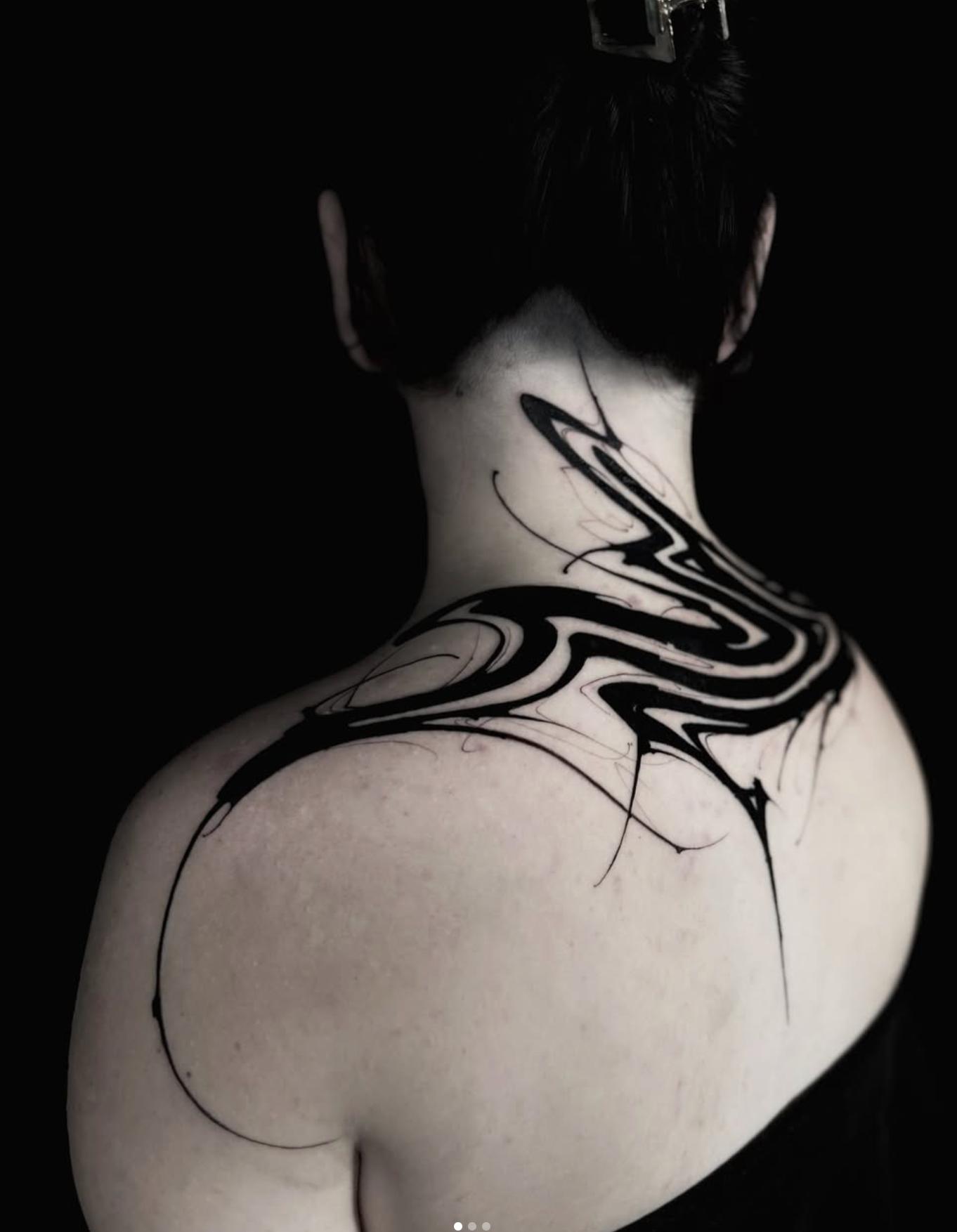 Abstract blackwork design on upper back and shoulder