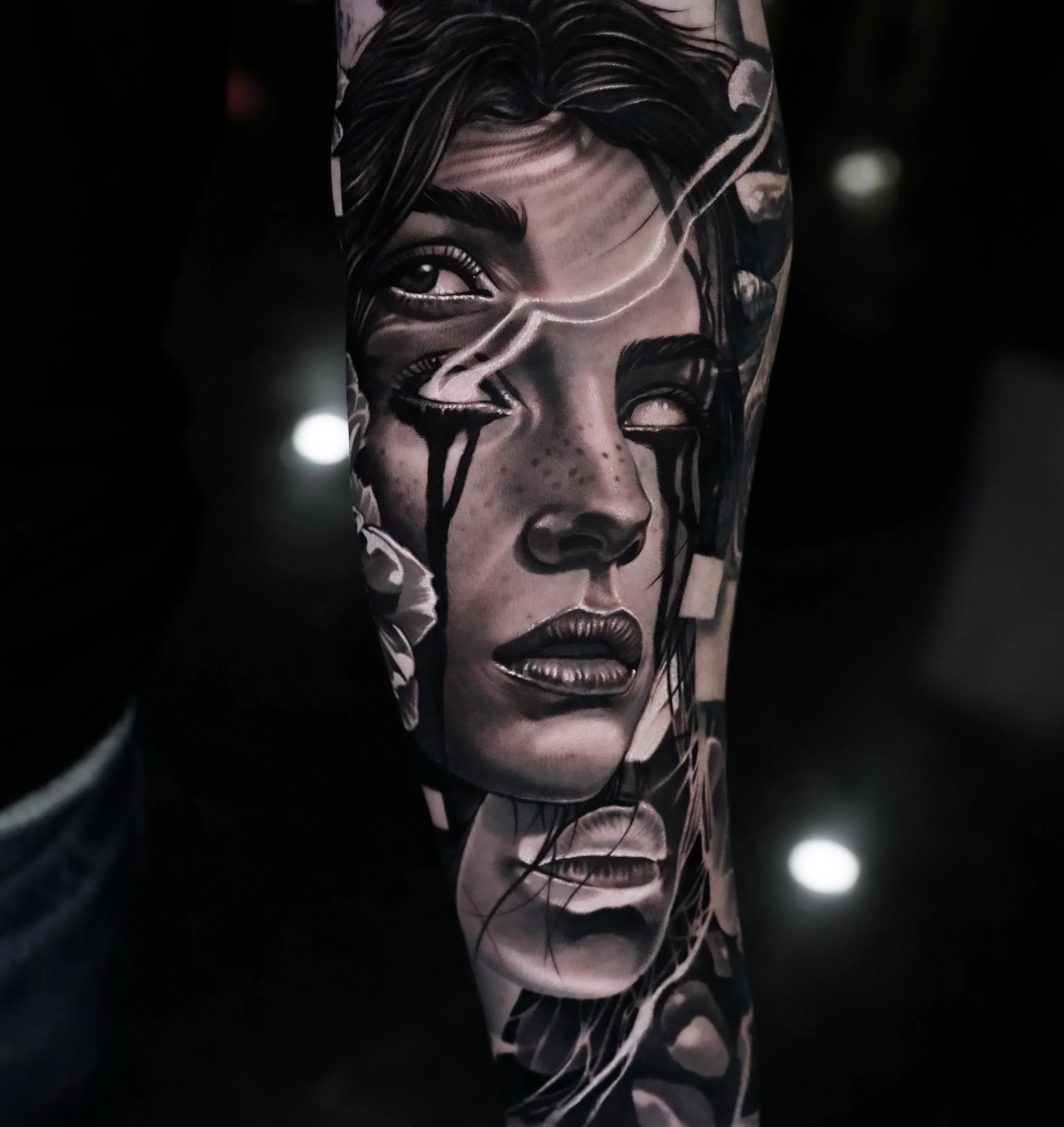 Black and grey realistic portrait tattoo on forearm featuring a woman's face.