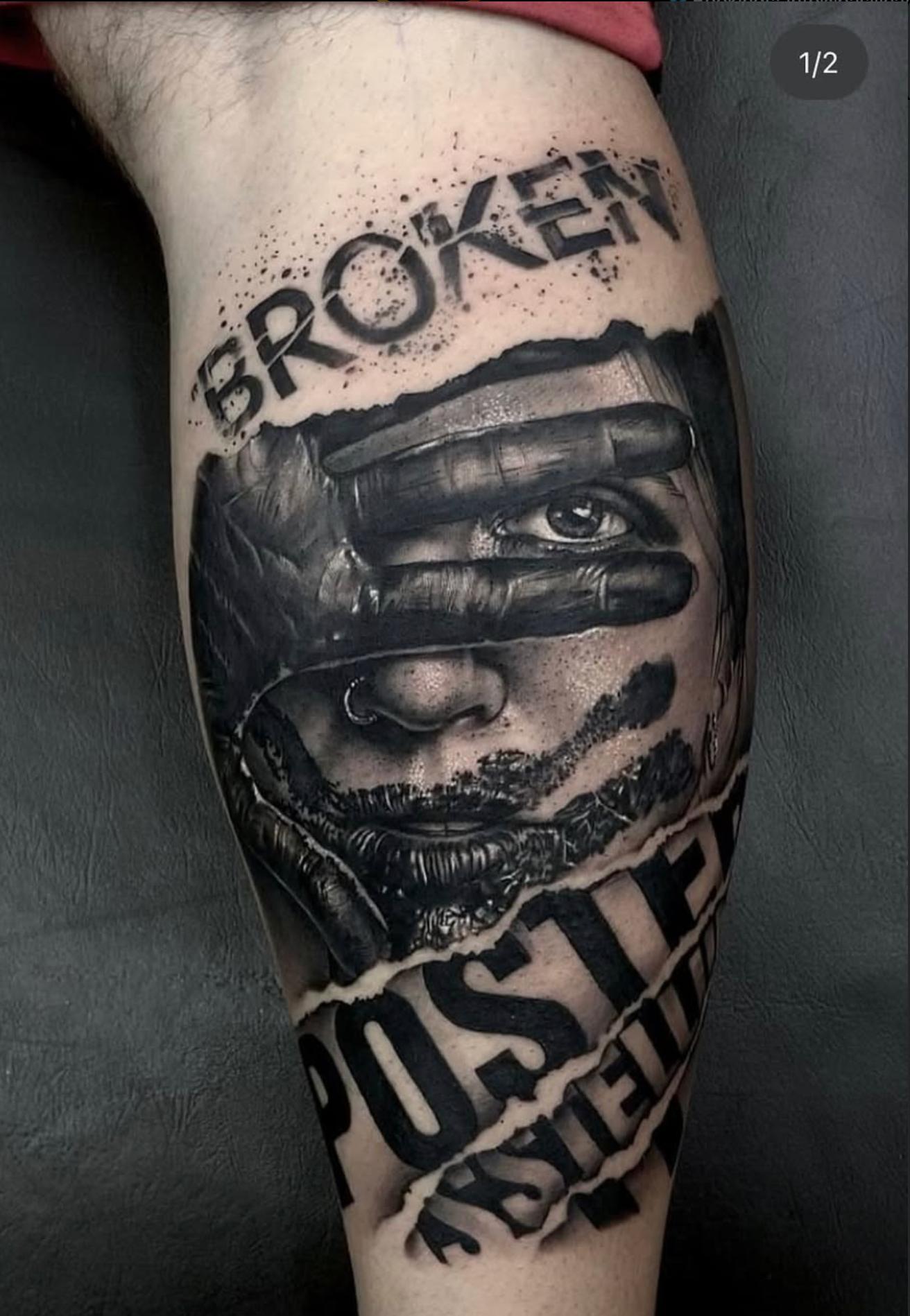 Black and grey realistic face and text tattoo on calf