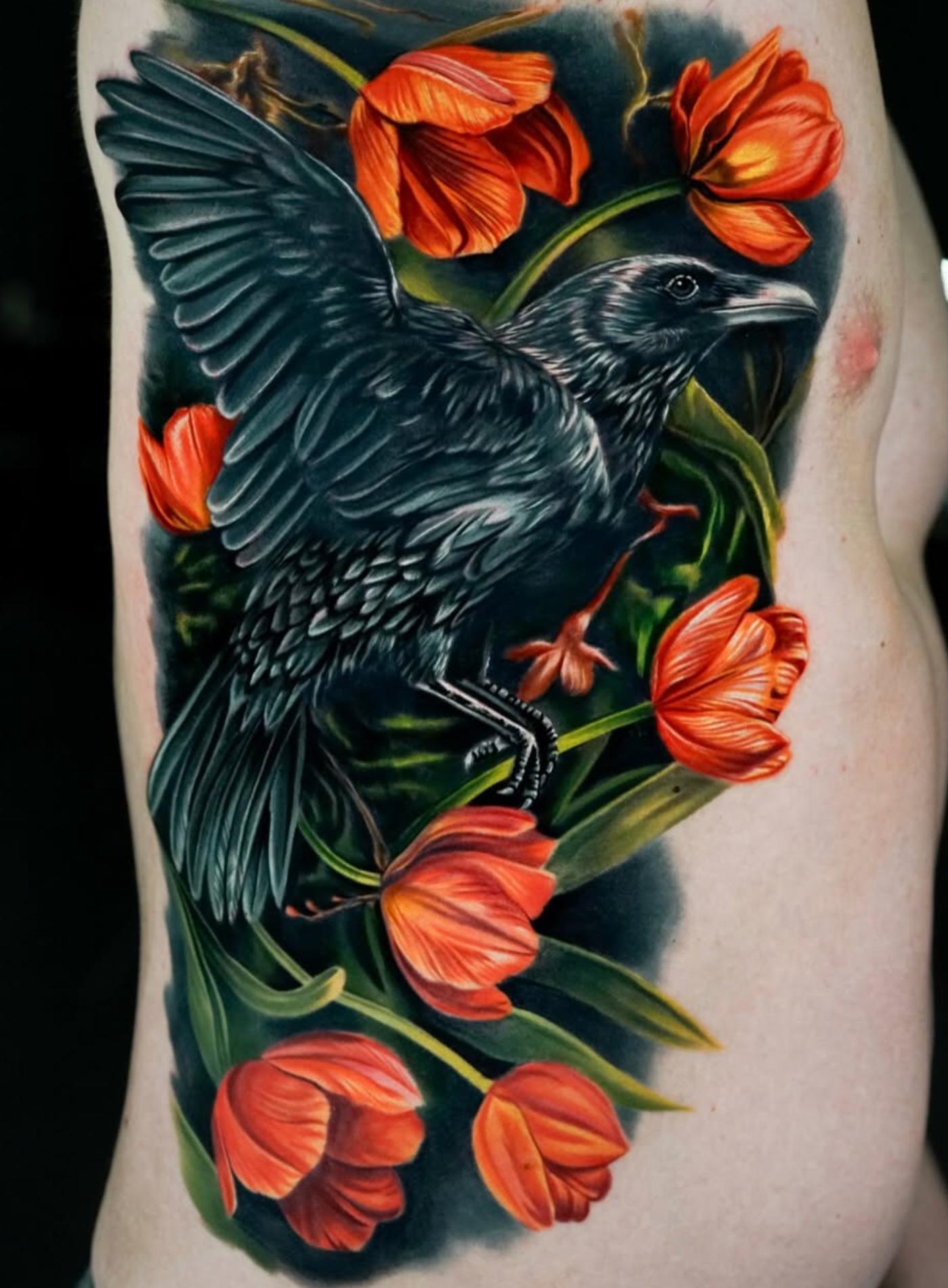 Colorful realistic raven with flowers tattoo on torso