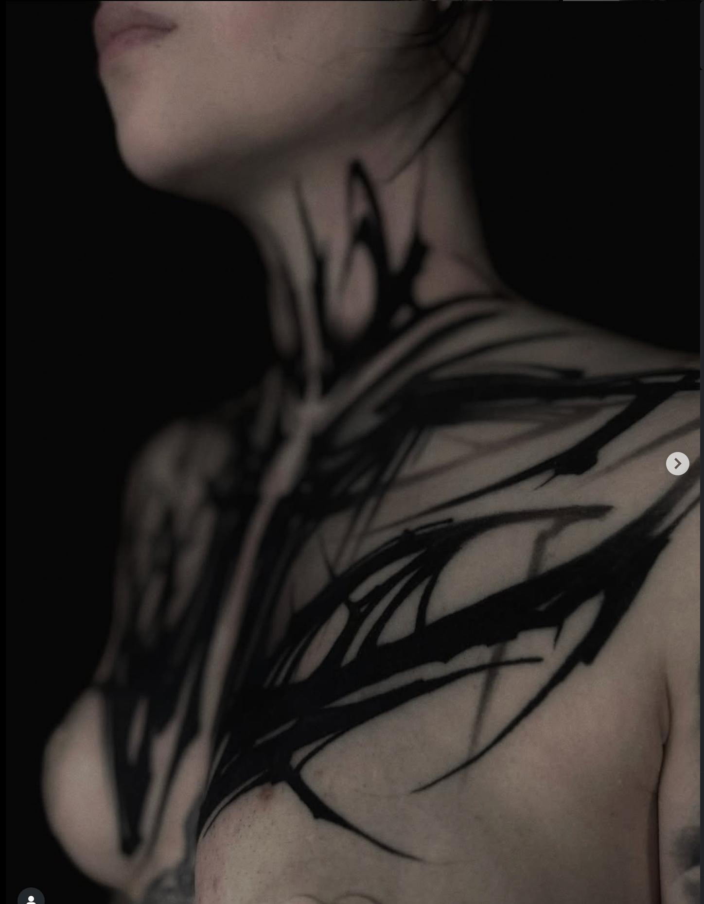 Blackwork abstract tattoo with bold lines on neck and chest