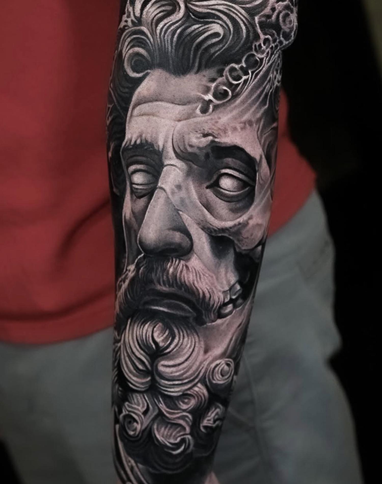 Black and grey realistic classical statue face on forearm