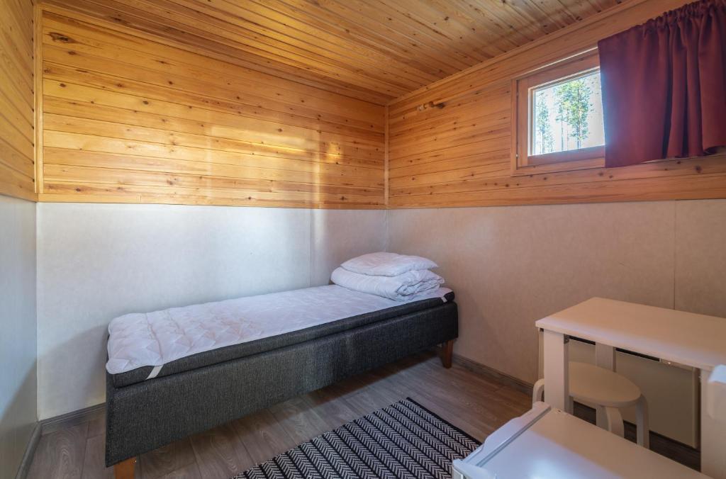 Interior of a compact single cottage with one bed at Ivalo River Camping