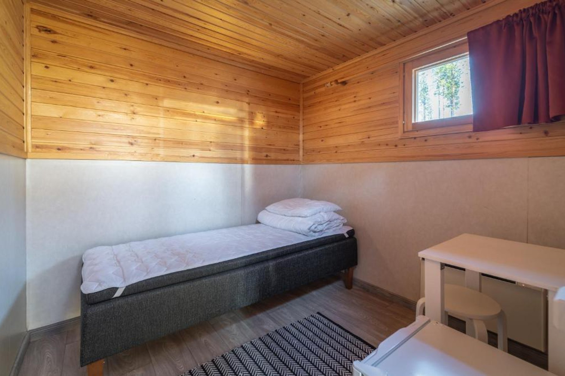 Interior of a compact single cottage with one bed at Ivalo River Camping