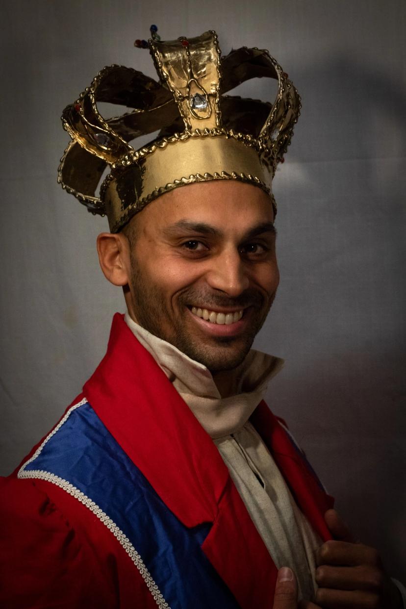 Konge i krone og rød, hvit og blå uniformsjakke.