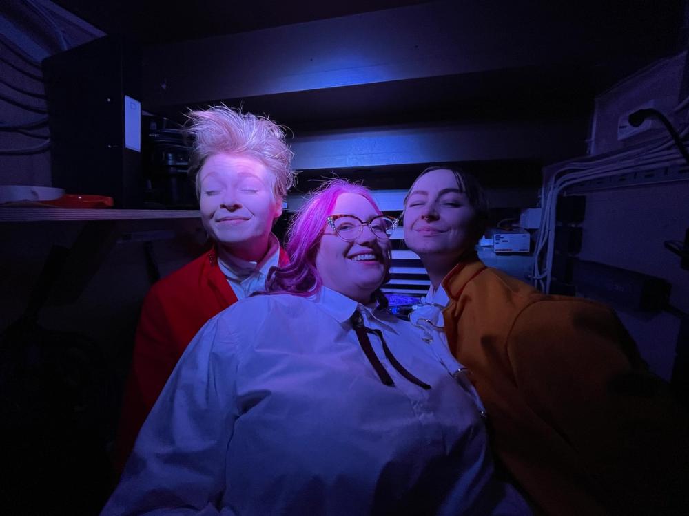 Tre skuespillere som smiler