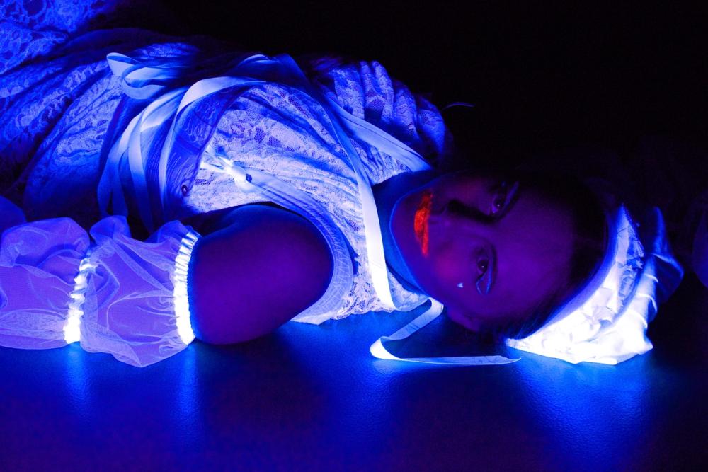 Andre heks ligger på gulvet og stirrer inn i kamera med glødende rød leppestift rundt munnen