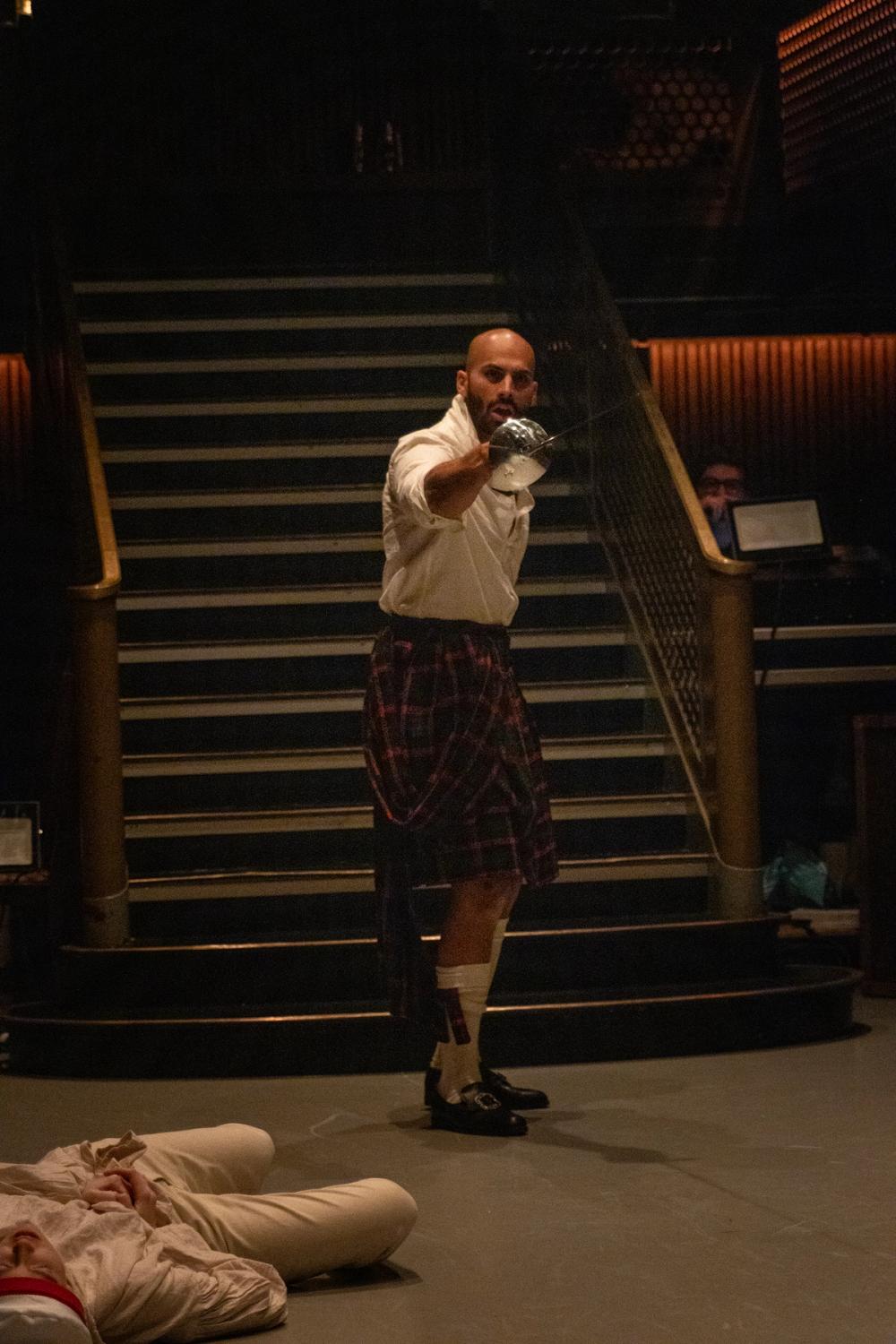 Macbeth står og roper noe, med sverdet parat.