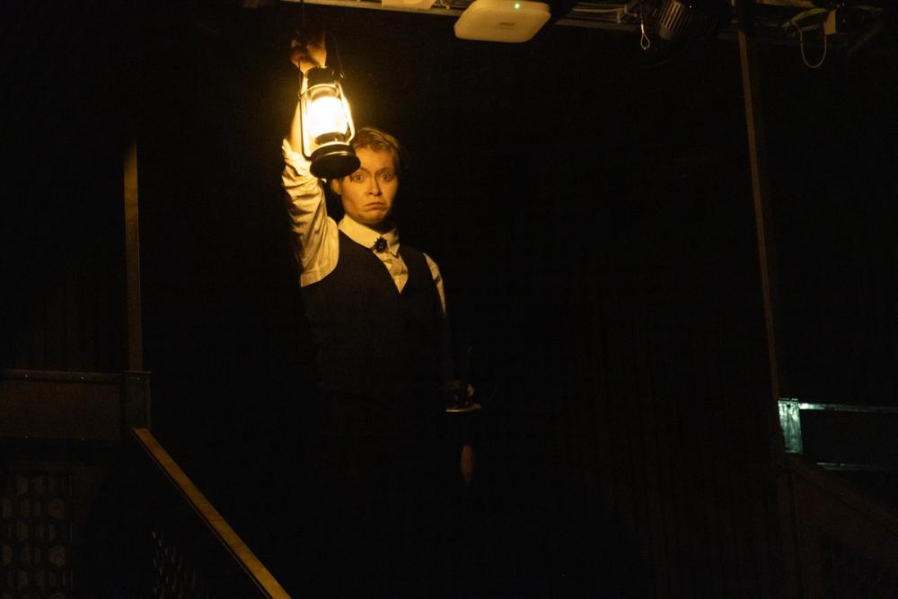 Adelsmann med lykt i toppen av trappa.